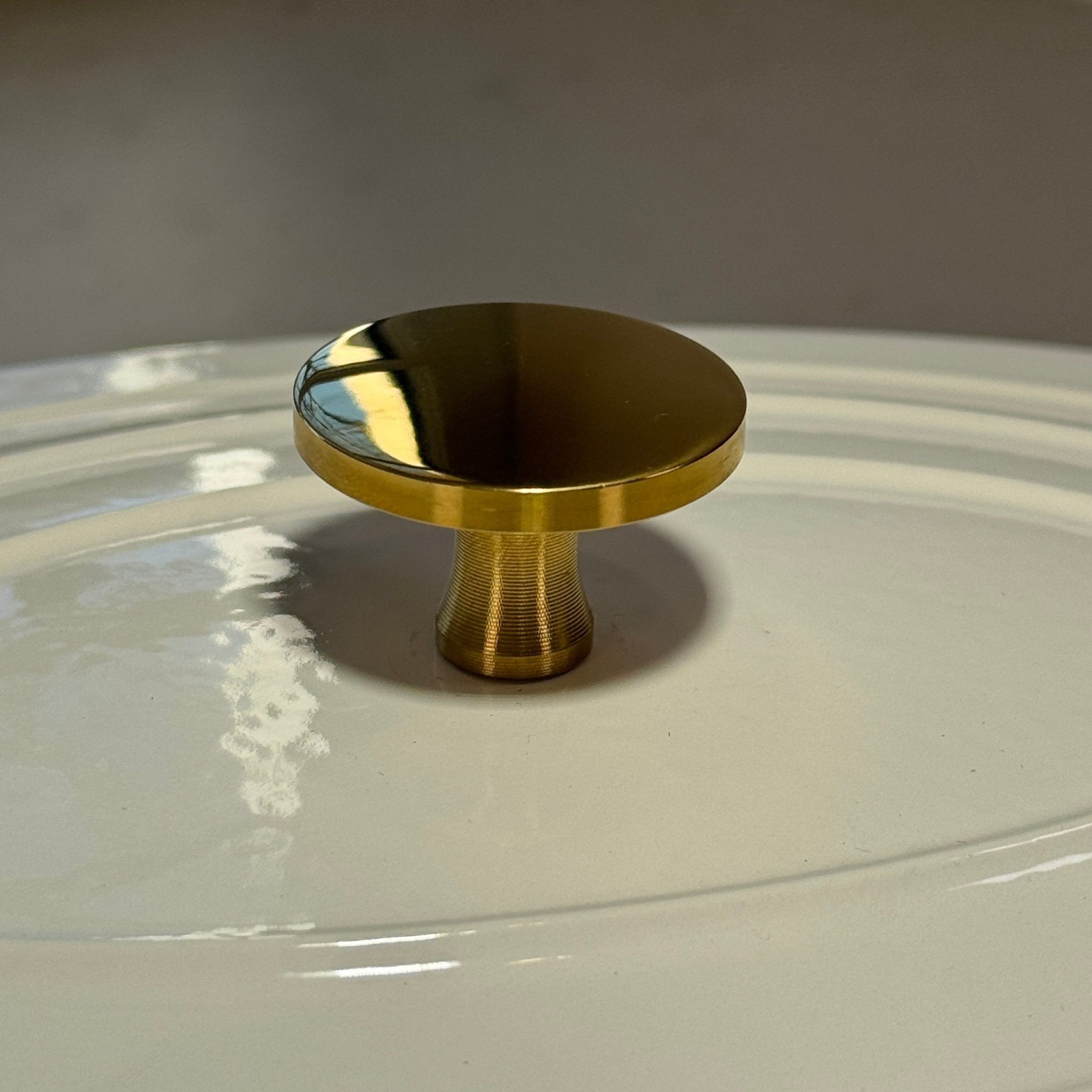 Shiny gold button adaptable to all lids