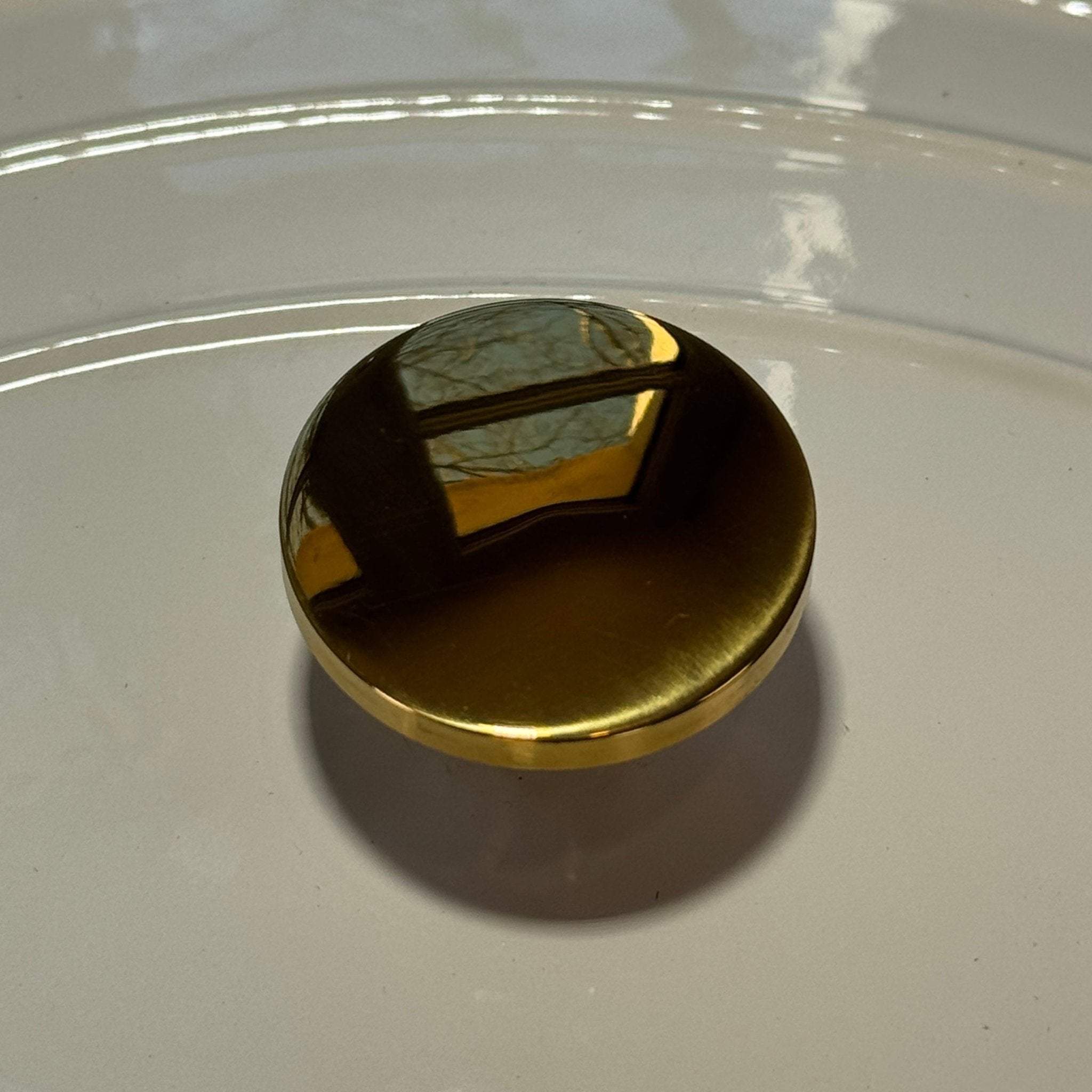 Shiny gold button adaptable to all lids