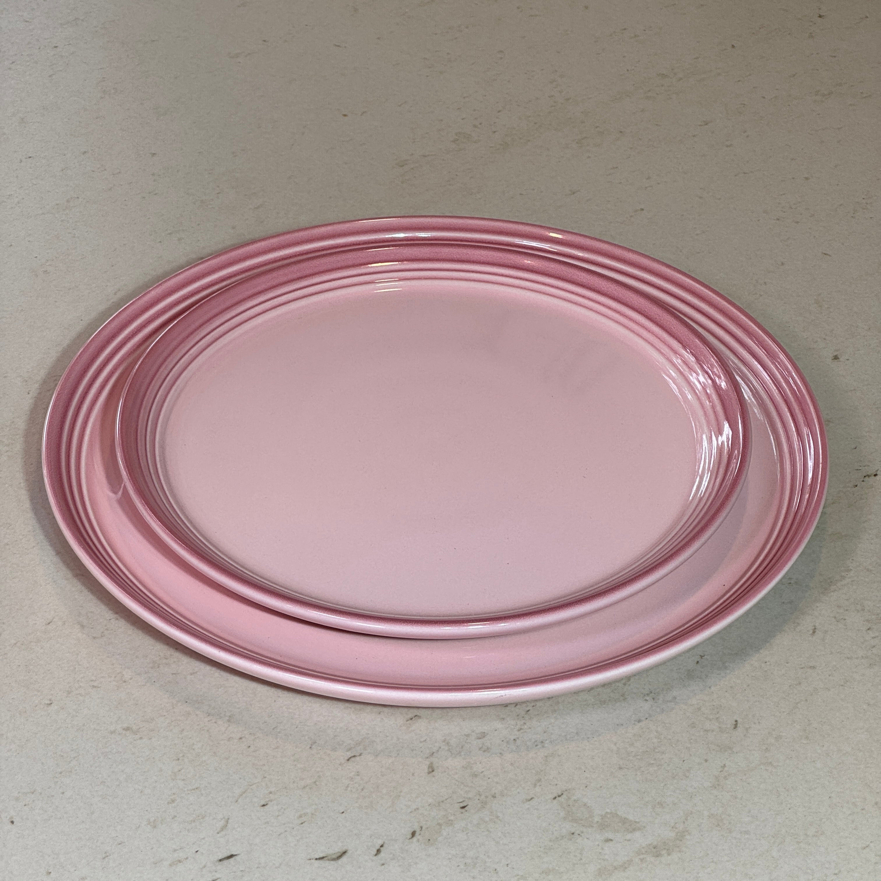 Assiette à dessert 22 cm et assiette plate 27 cm en céramique émaillée rose, idéales pour dresser une table élégante.