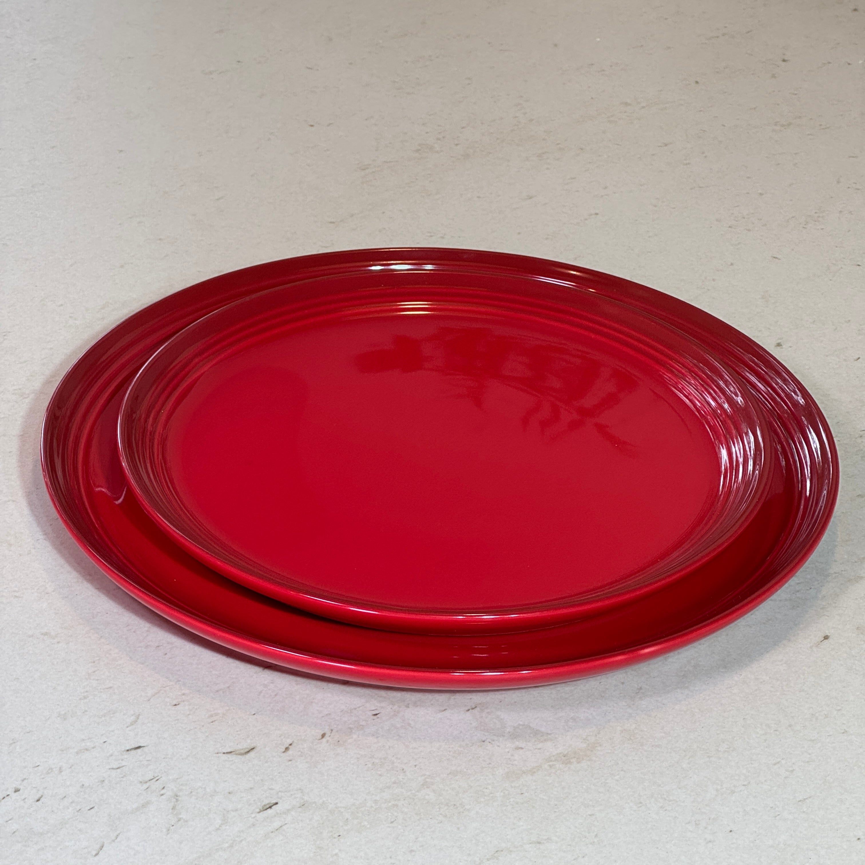 Assiette à dessert 22 cm et assiette plate 27 cm en céramique émaillée rouge, idéales pour dresser une table élégante.