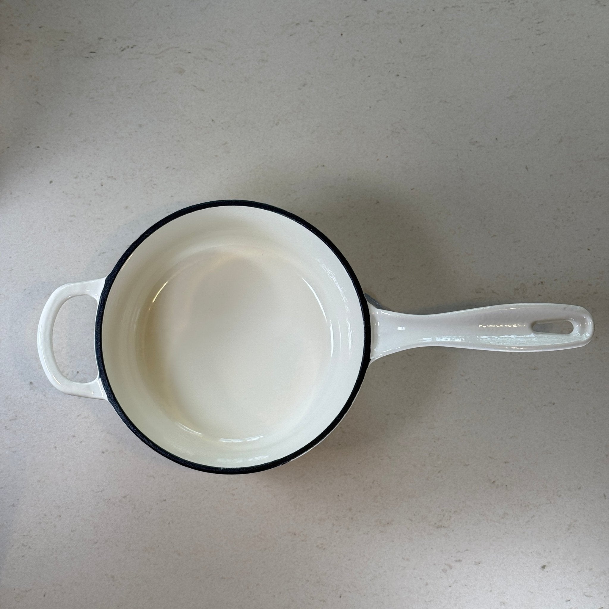 Intérieur anti adhésif clair d’une casserole en fonte émaillée Blanc Vanille idéale pour sauces, crèmes et préparations délicates