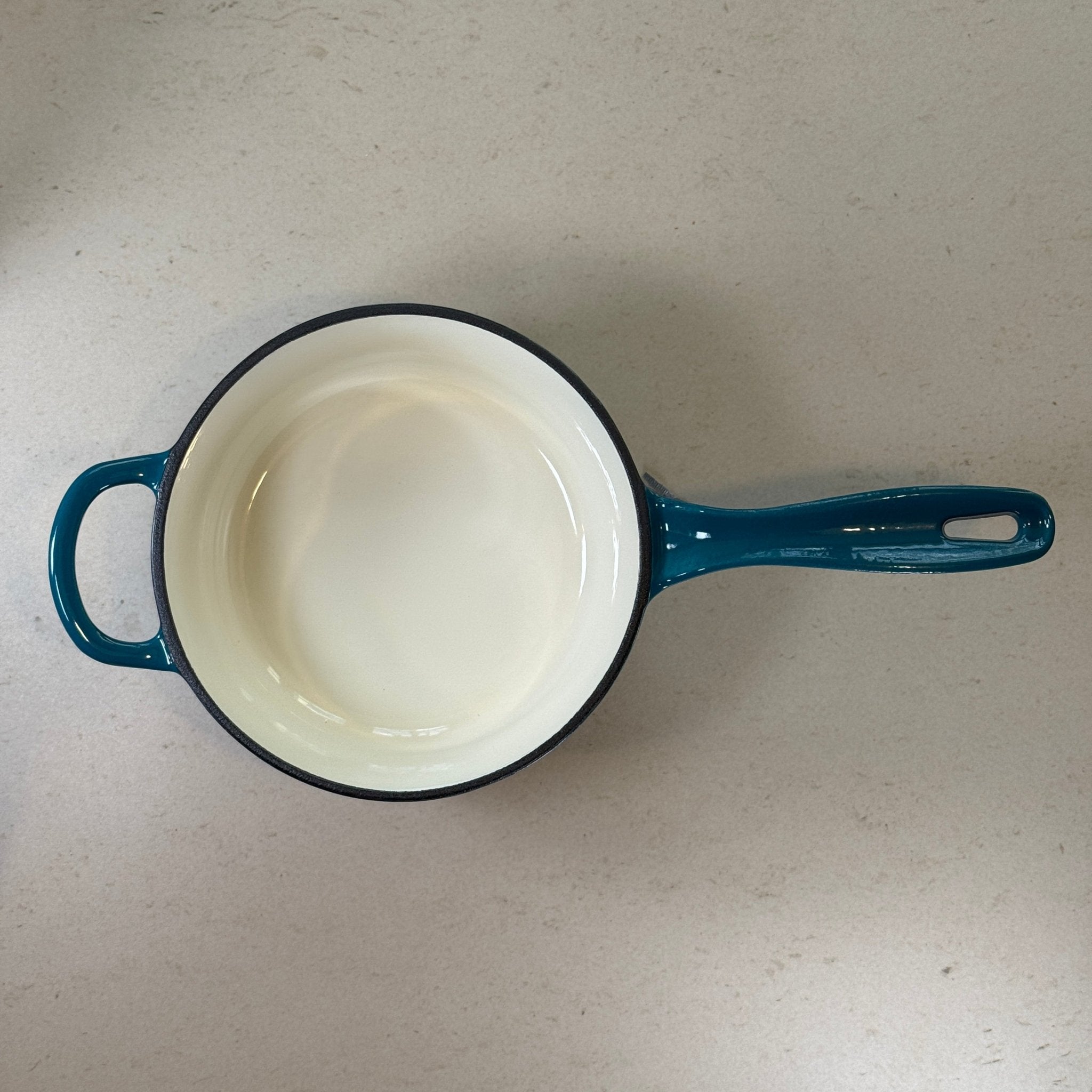 Intérieur anti adhésif clair d’une casserole en fonte émaillée Bleu Cyan idéale pour sauces, crèmes et préparations délicates