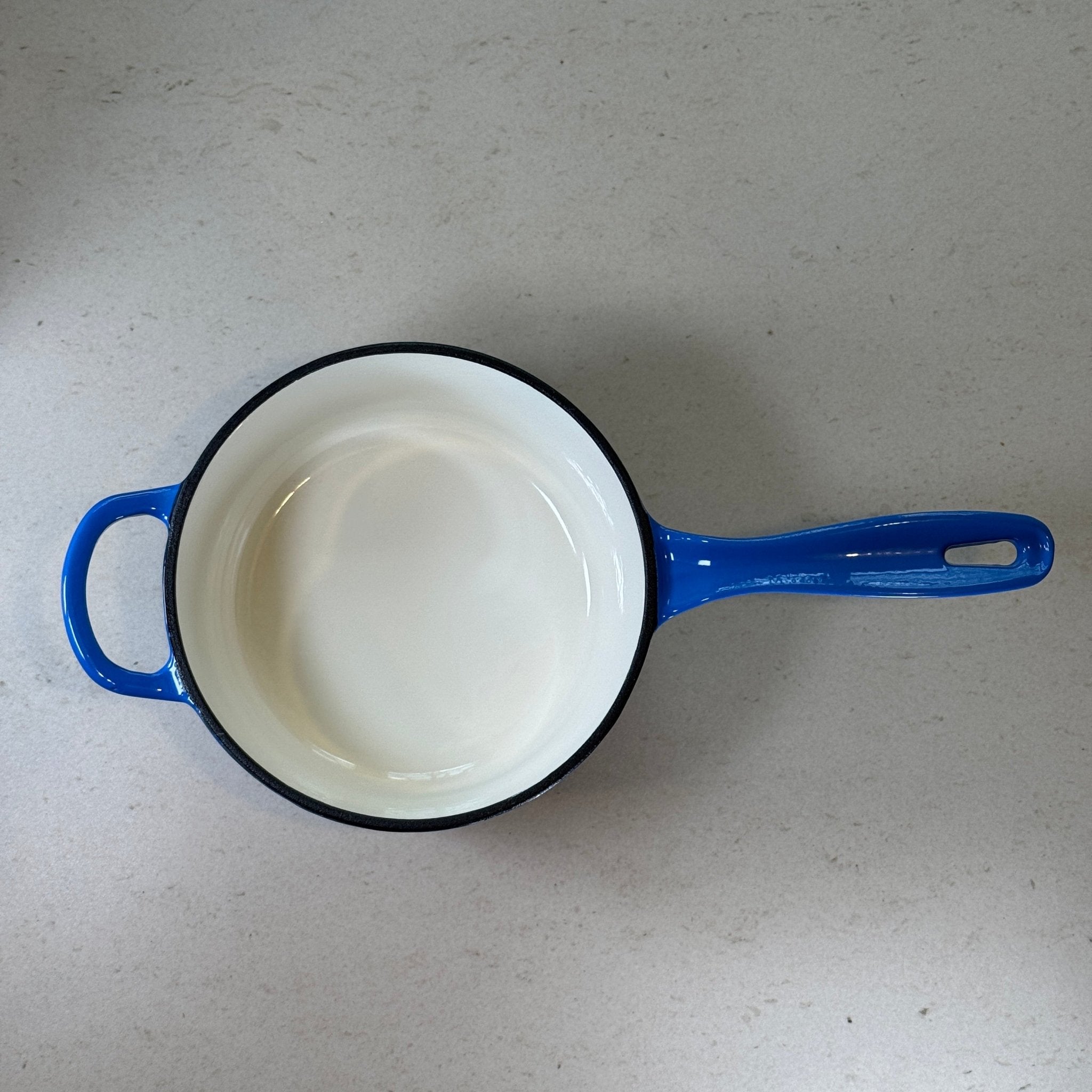 Intérieur anti adhésif clair d’une casserole en fonte émaillée Bleu Myrtille idéale pour sauces, crèmes et préparations délicates