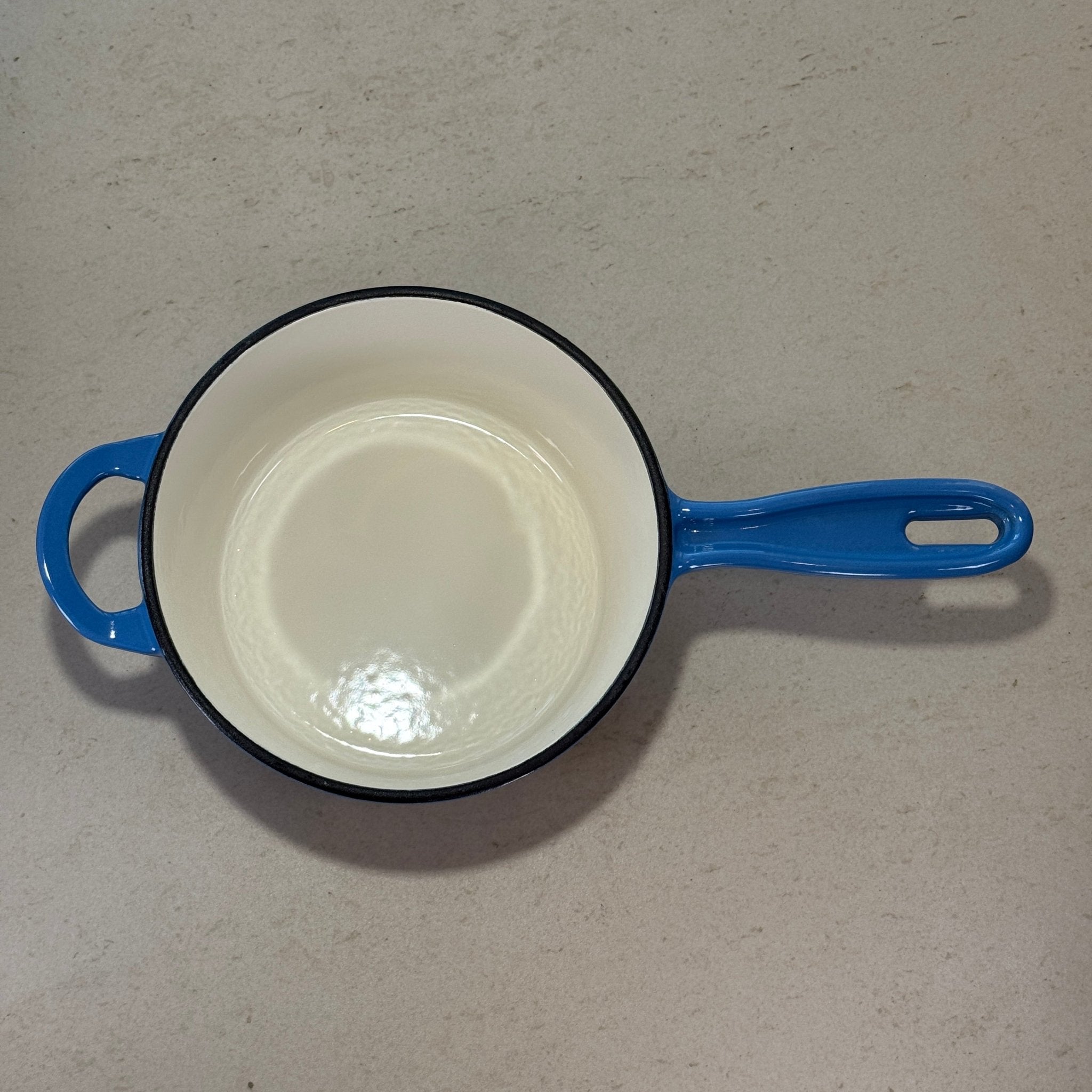 Intérieur anti adhésif clair d’une casserole en fonte émaillée Bleu Perle idéale pour sauces, crèmes et préparations délicates