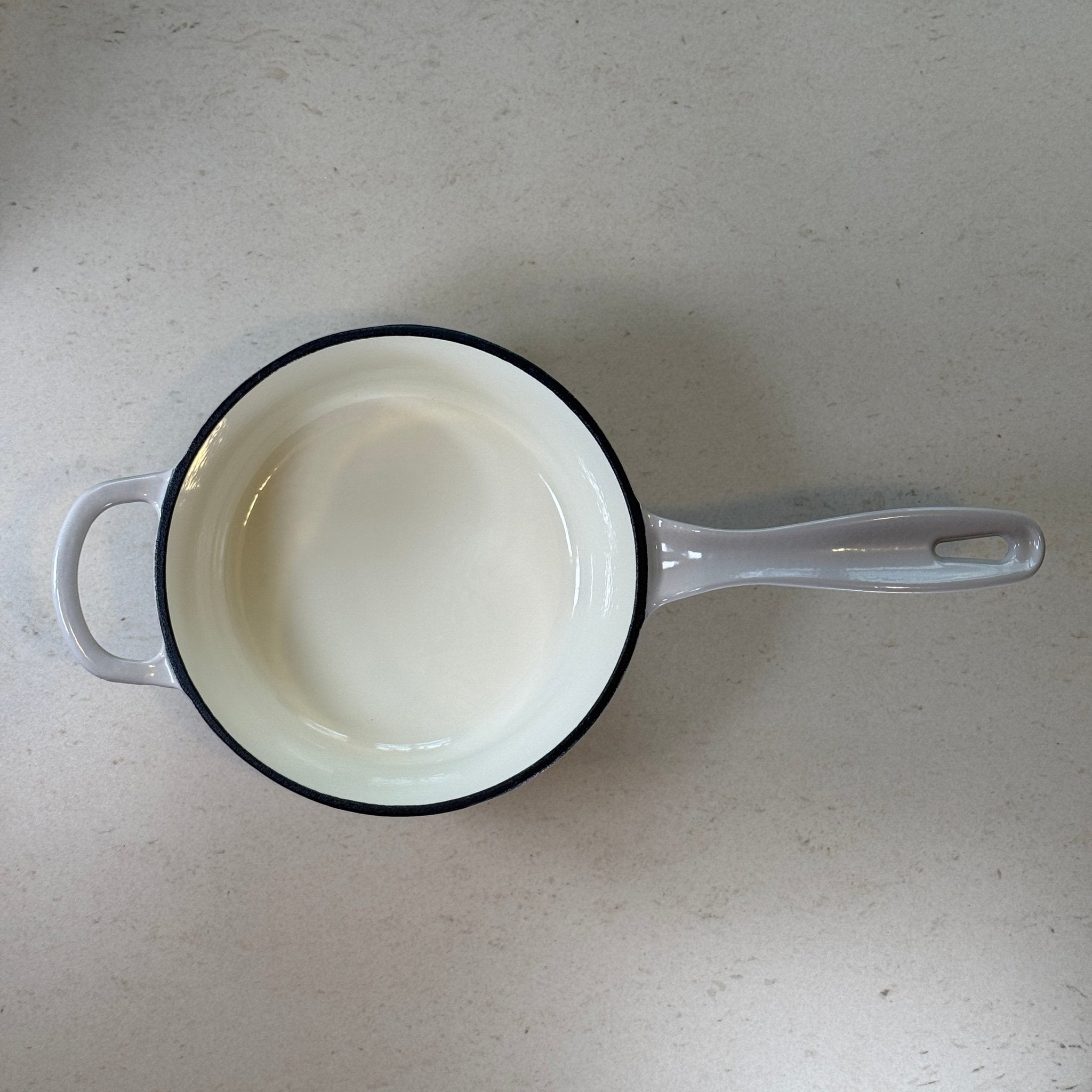 Intérieur anti adhésif clair d’une casserole en fonte émaillée Gris Meringue idéale pour sauces, crèmes et préparations délicates