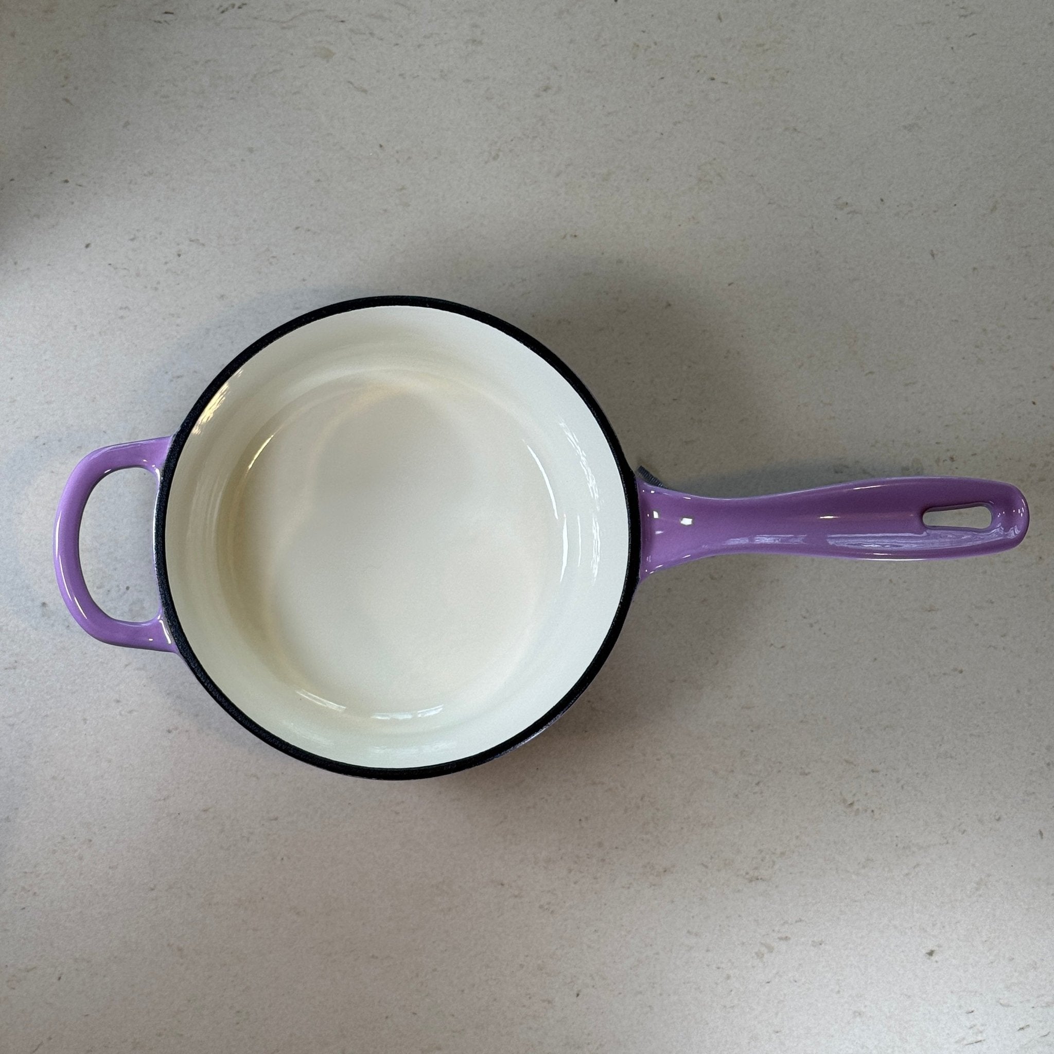 Intérieur anti adhésif clair d’une casserole en fonte émaillée Violet Prune idéale pour sauces, crèmes et préparations délicates