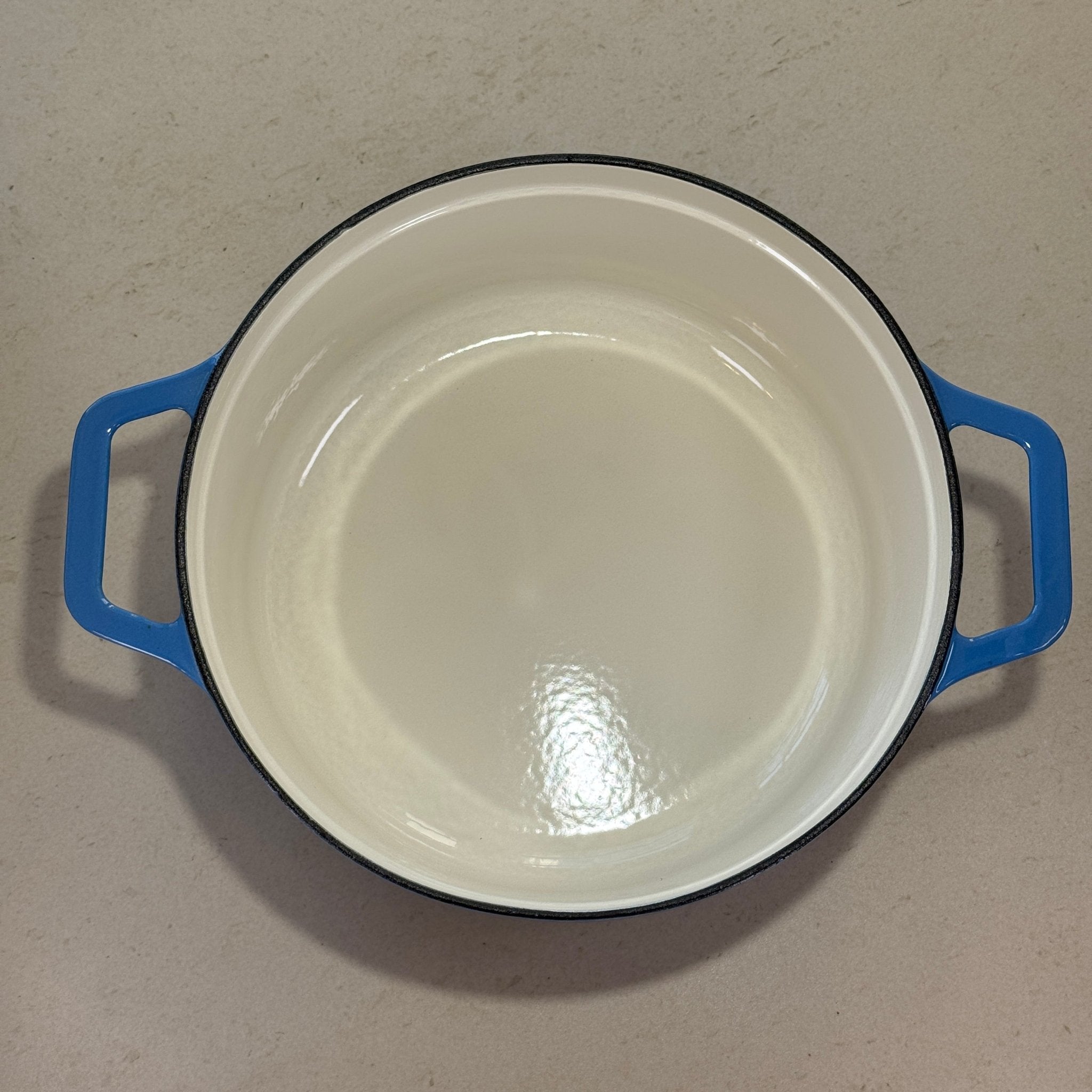 Intérieur anti adhésif clair d’une cocotte classique en fonte émaillée Bleu Perle pour cuisson homogène et facile à nettoyer