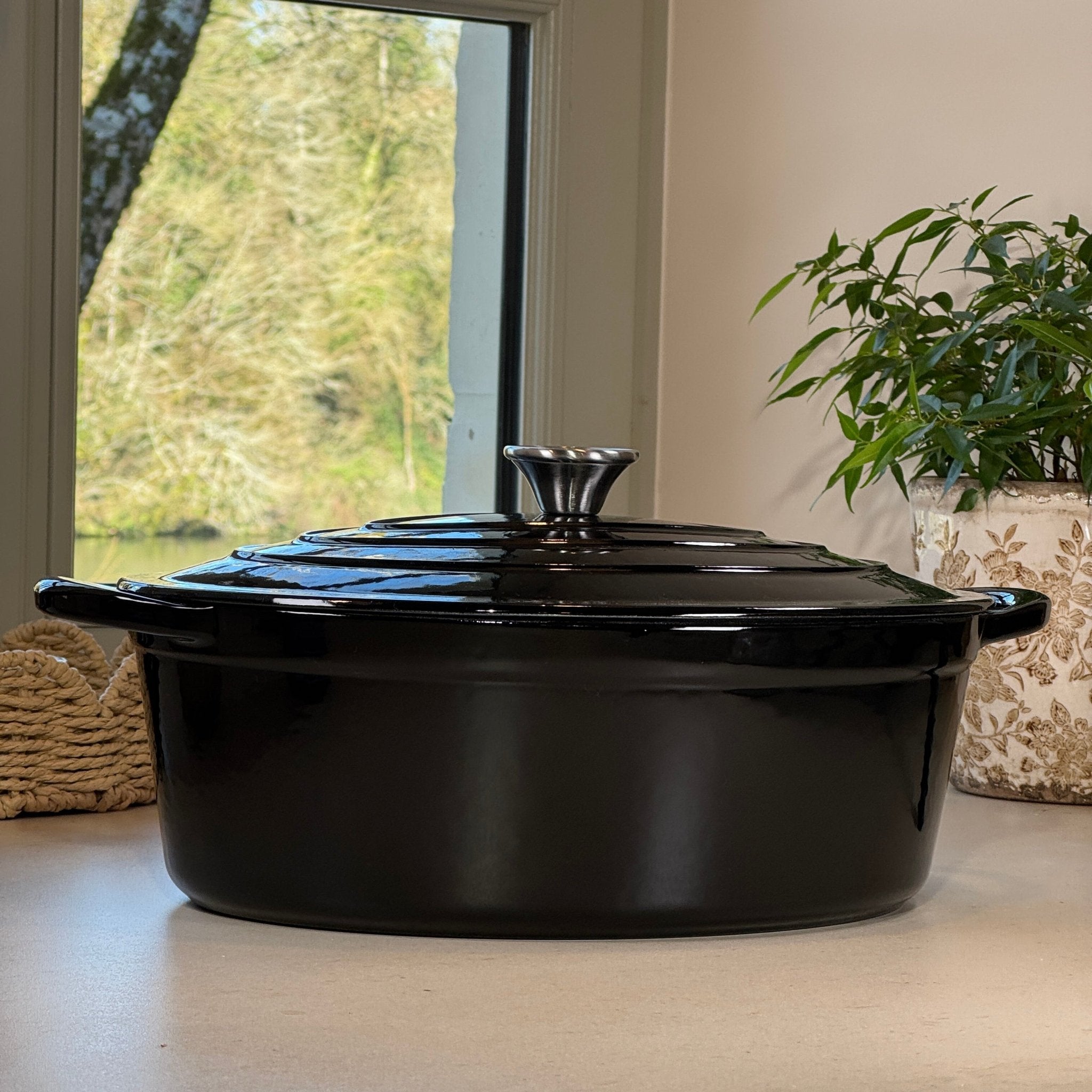 Cocotte ovale en fonte émaillée noir brillant posée sur plan de cuisine moderne