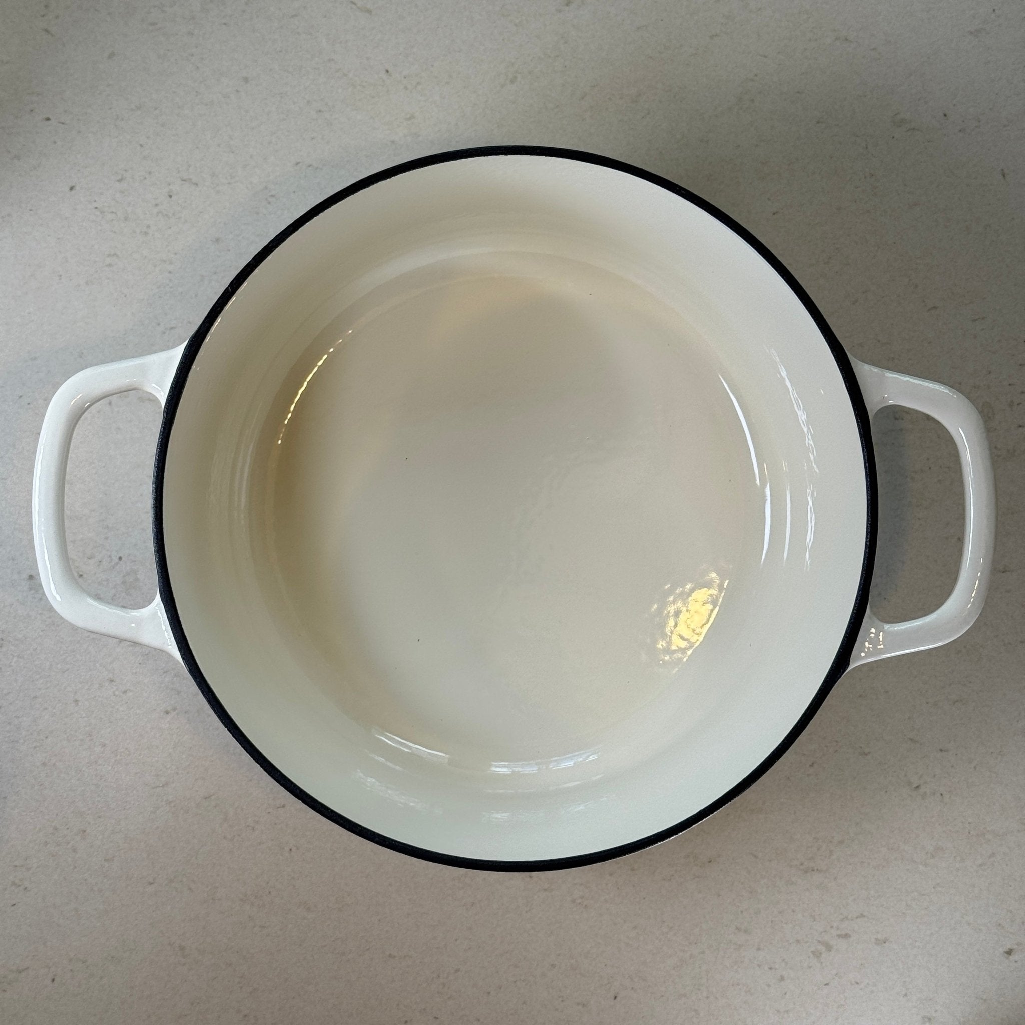 Intérieur anti adhésif clair d’une cocotte en fonte émaillée Blanc Vanille pour cuisson homogène et facile à nettoyer