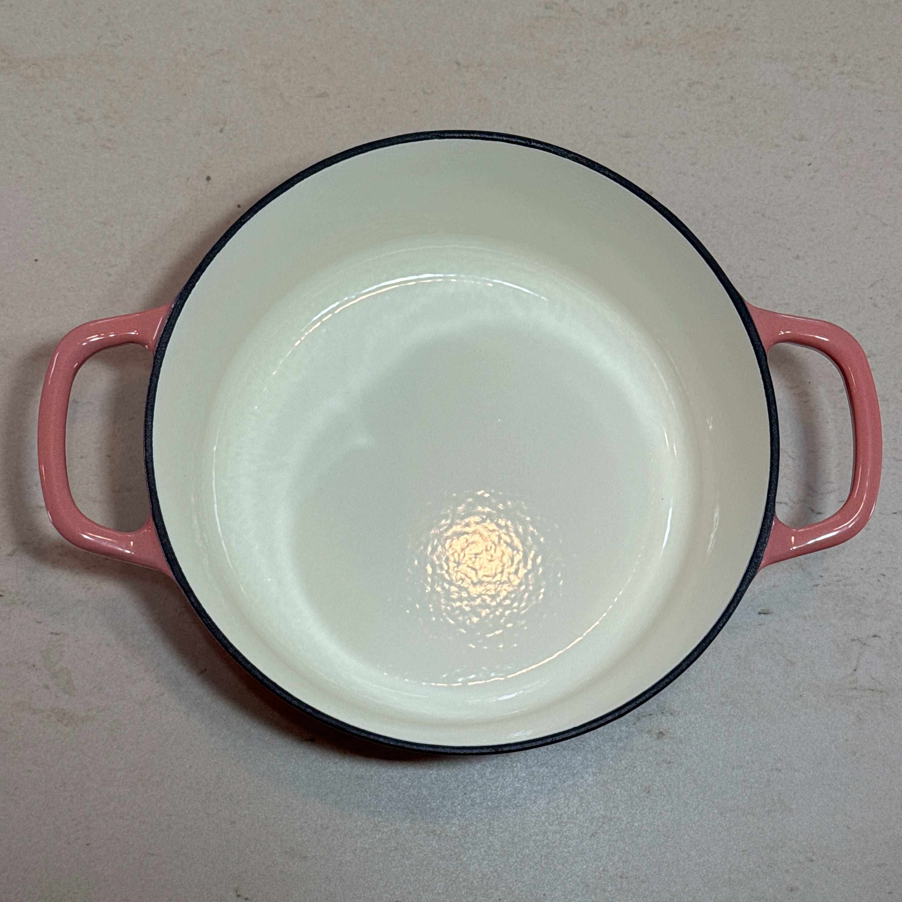 Intérieur anti adhésif clair d’une cocotte ronde en fonte émaillée Rose pour cuisson homogène et facile à nettoyer