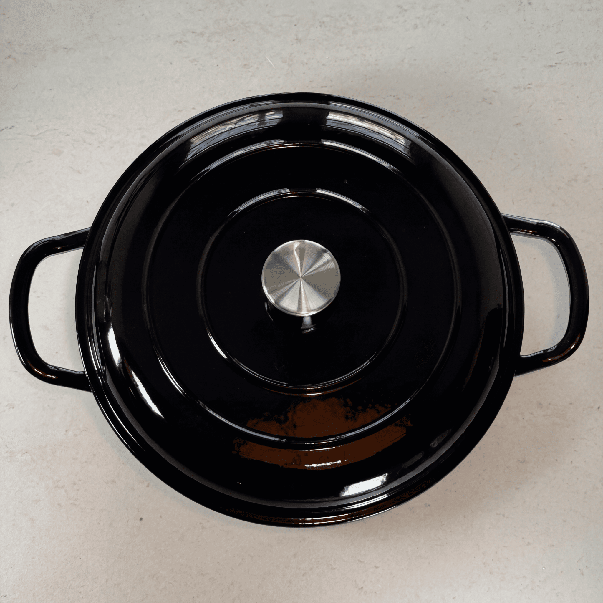 Faitout en fonte émaillée noir brillant avec couvercle à picots assurant un arrosage naturel des plats pendant la cuisson