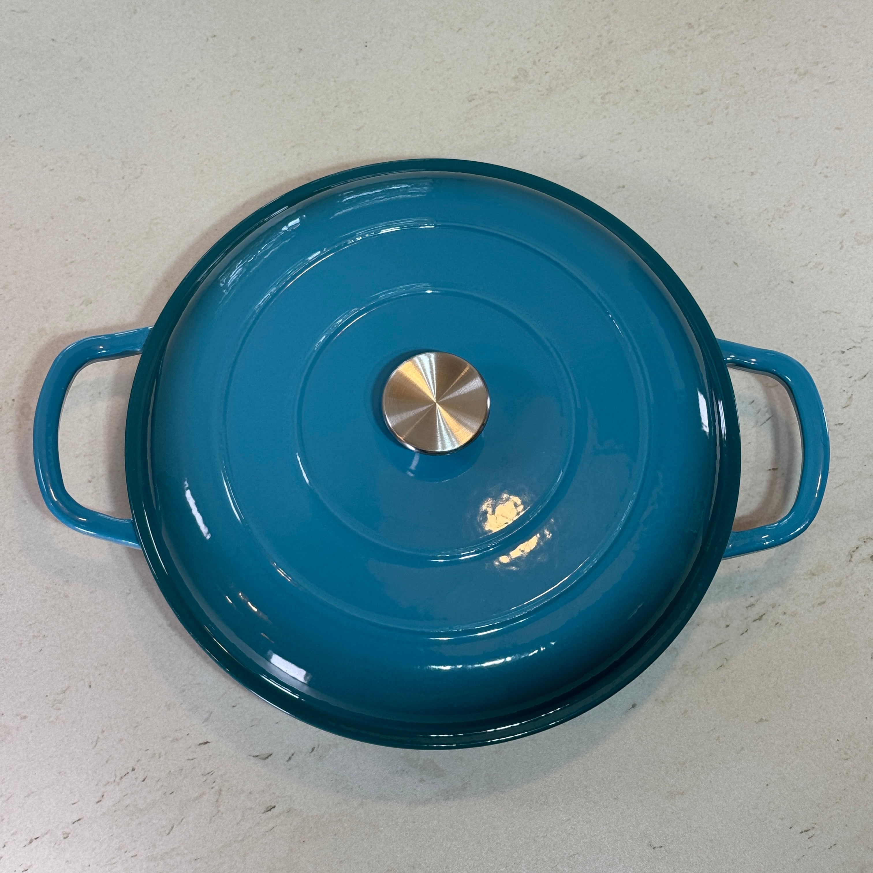 Faitout en fonte émaillée turquoise avec couvercle à picots assurant un arrosage naturel des plats pendant la cuisson
