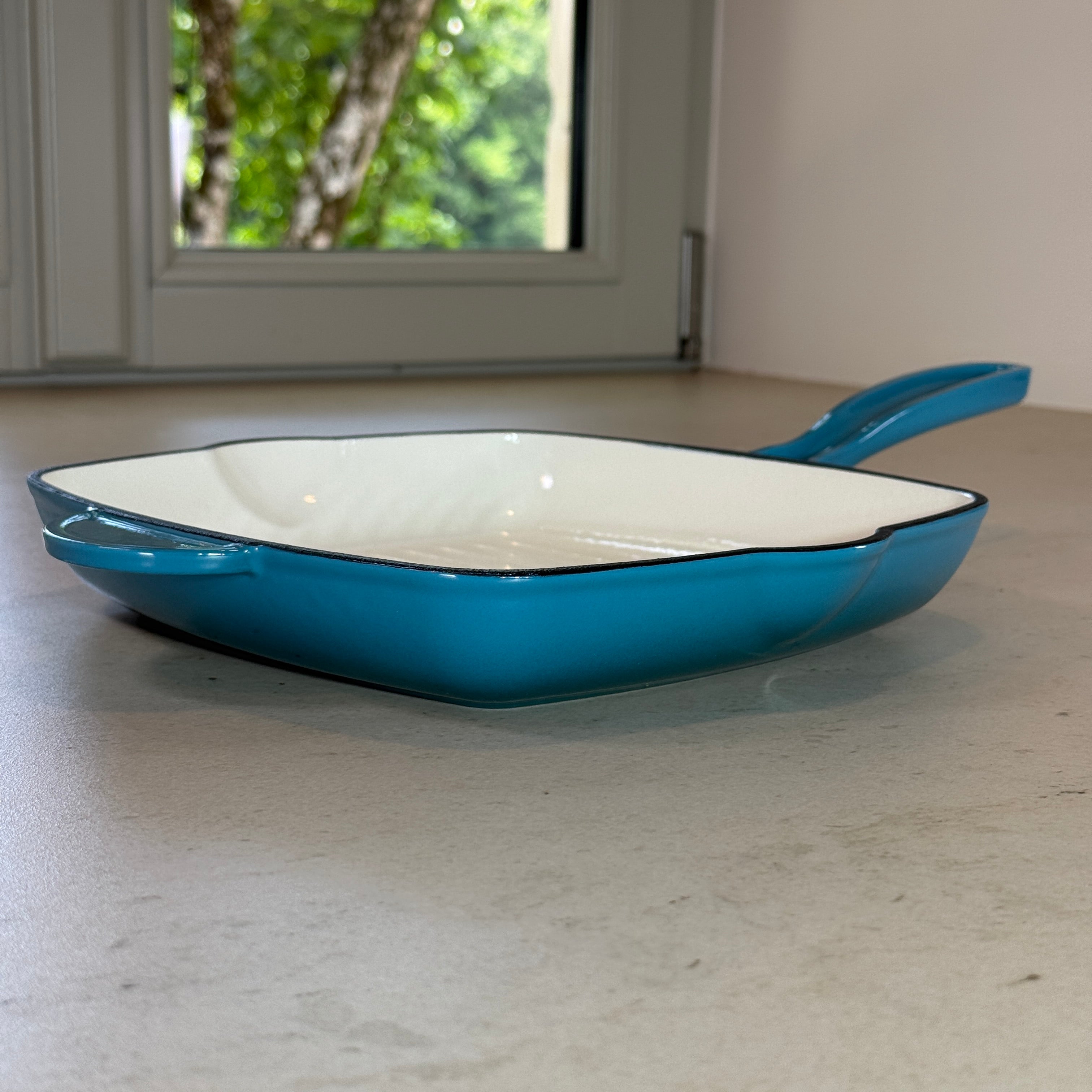 Grill en fonte émaillée turquoise avec poignée ergonomique pour grillades estivales, poissons et légumes grillés