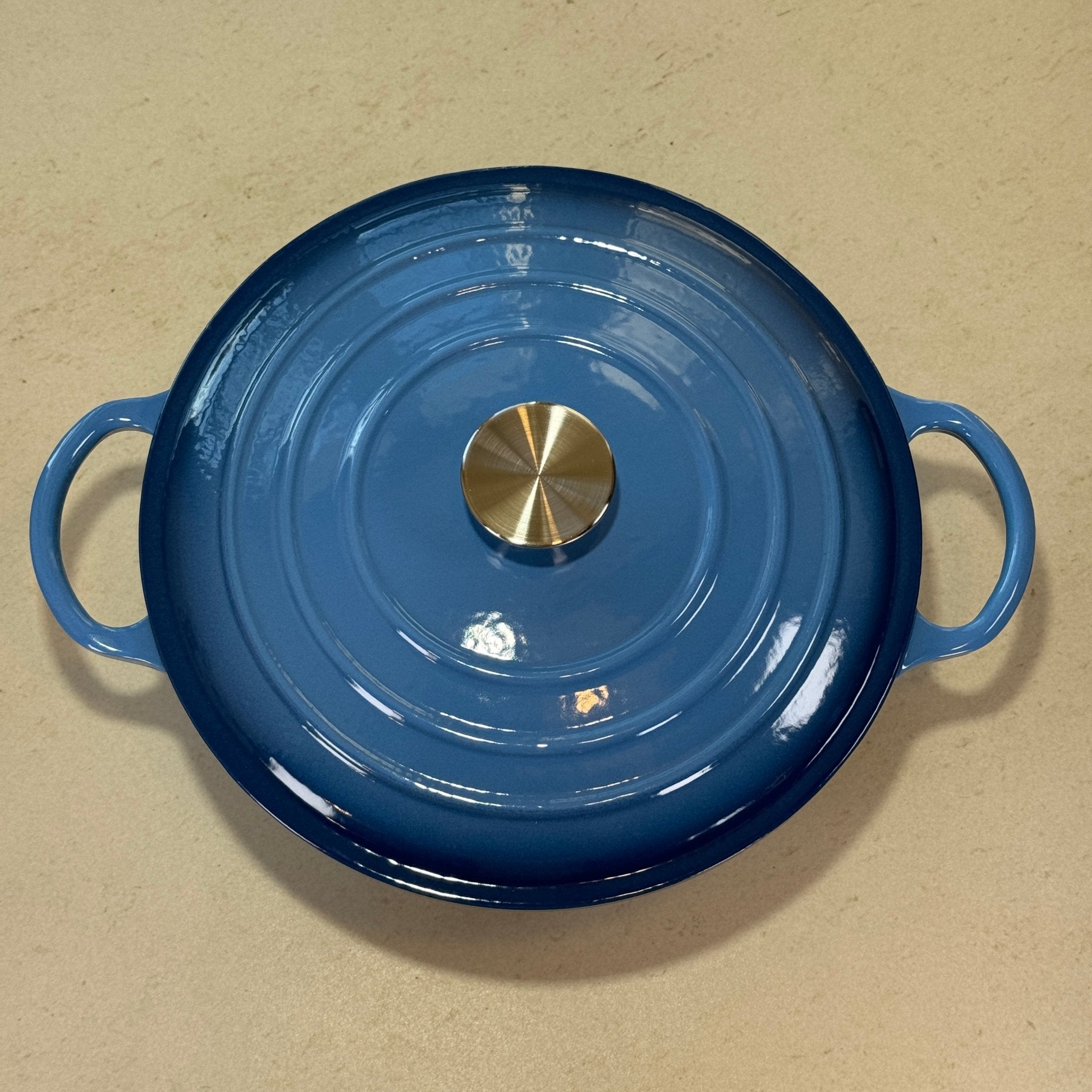 Marmite ronde en fonte émaillée bleu perle adaptée à la cuisson de sauces, béchamel et préparations à base de lait