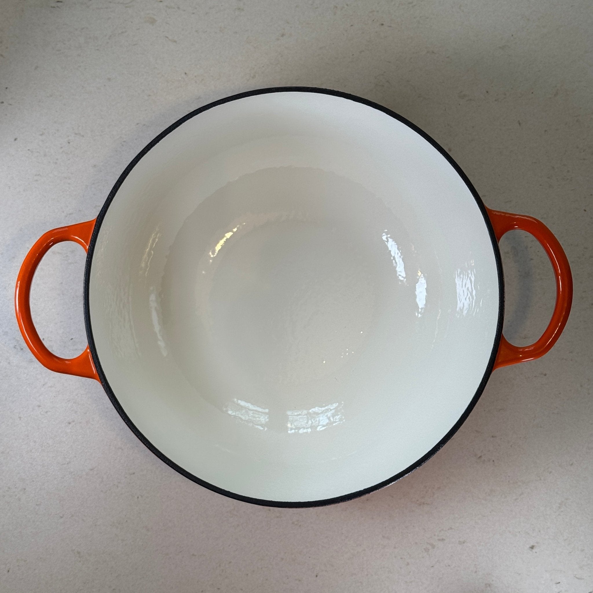 Marmite en fonte émaillée orange à bords arrondis facilitant le mélange des potages, veloutés et crèmes dessert