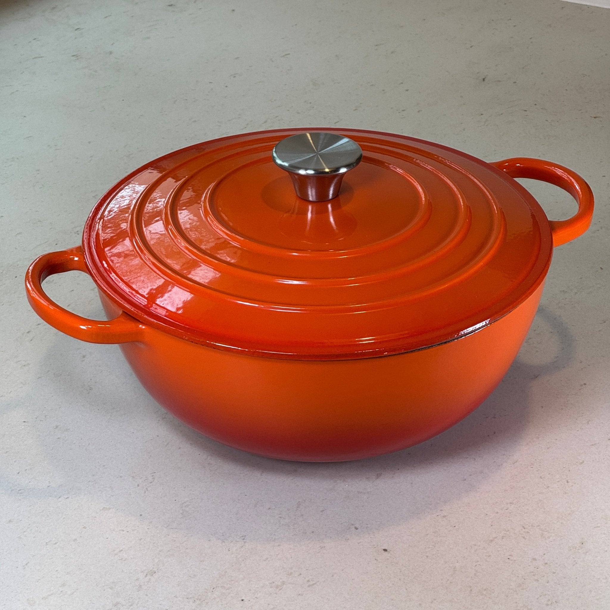 Marmite ronde en fonte émaillée orange conçue pour une cuisson douce et maîtrisée des préparations liquides