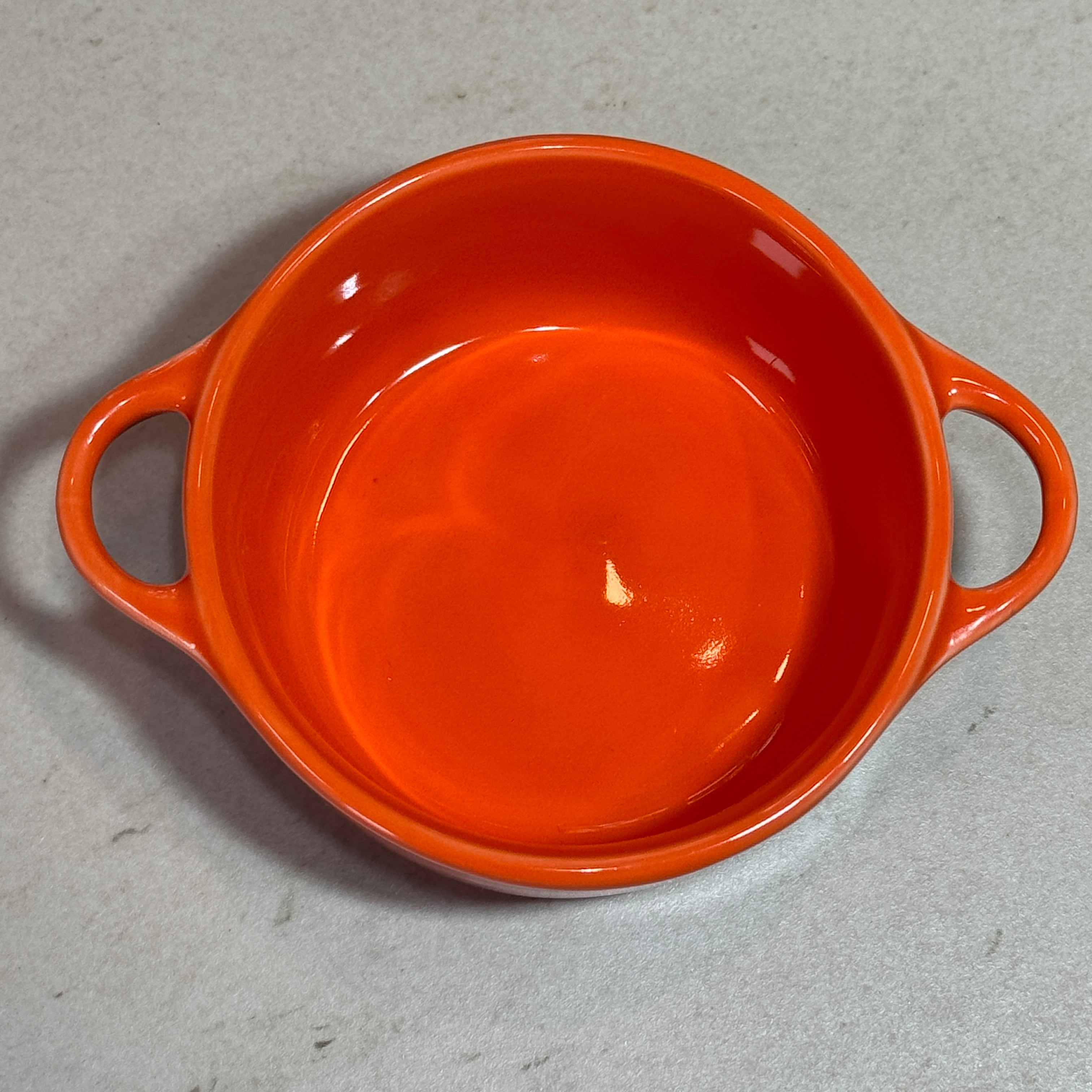 Intérieur de la mini cocotte en céramique émaillée 220 ml orange avec poignées, idéale pour les plats individuels.