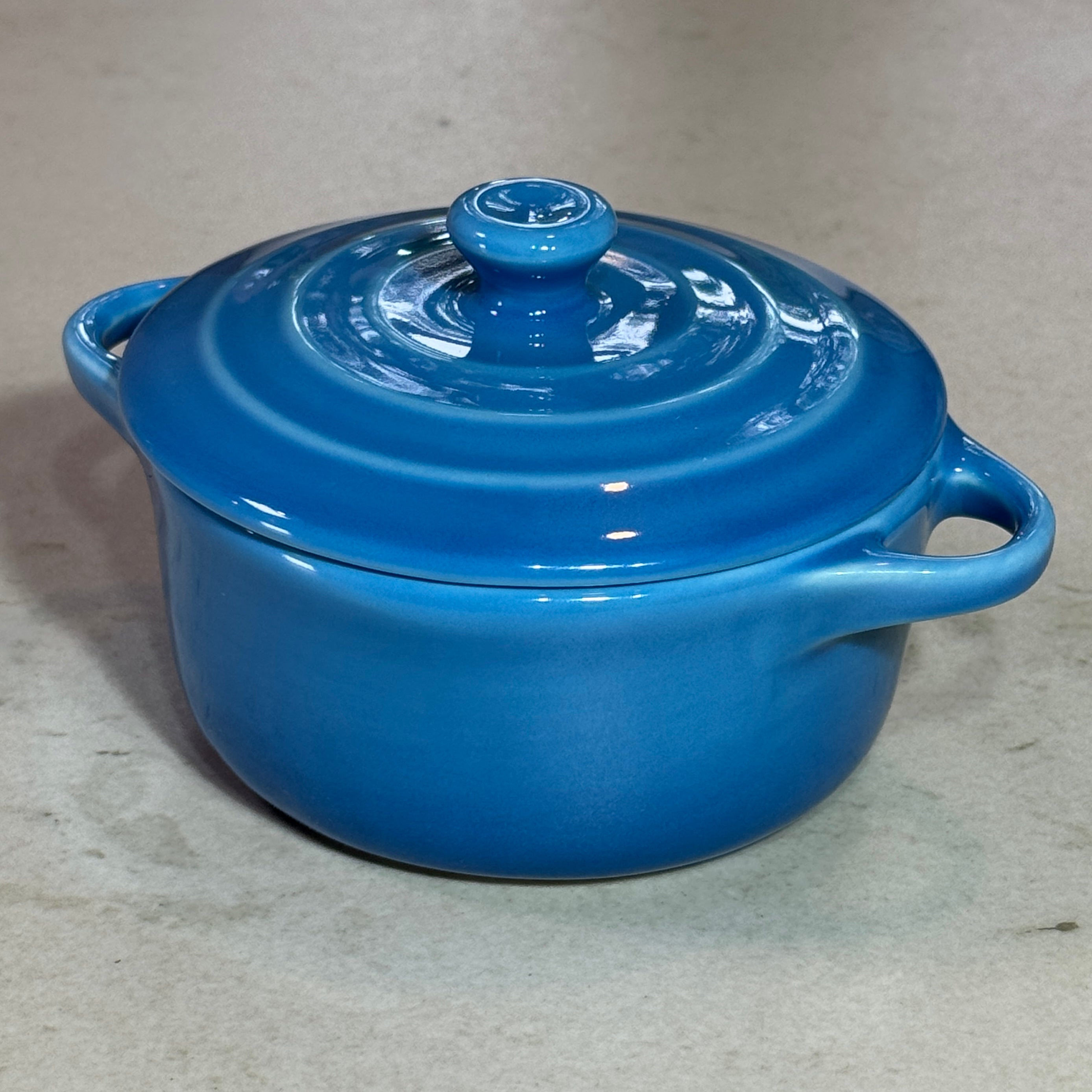 Vue de profil de la mini cocotte en céramique émaillée bleu 220 ml avec poignées et couvercle.