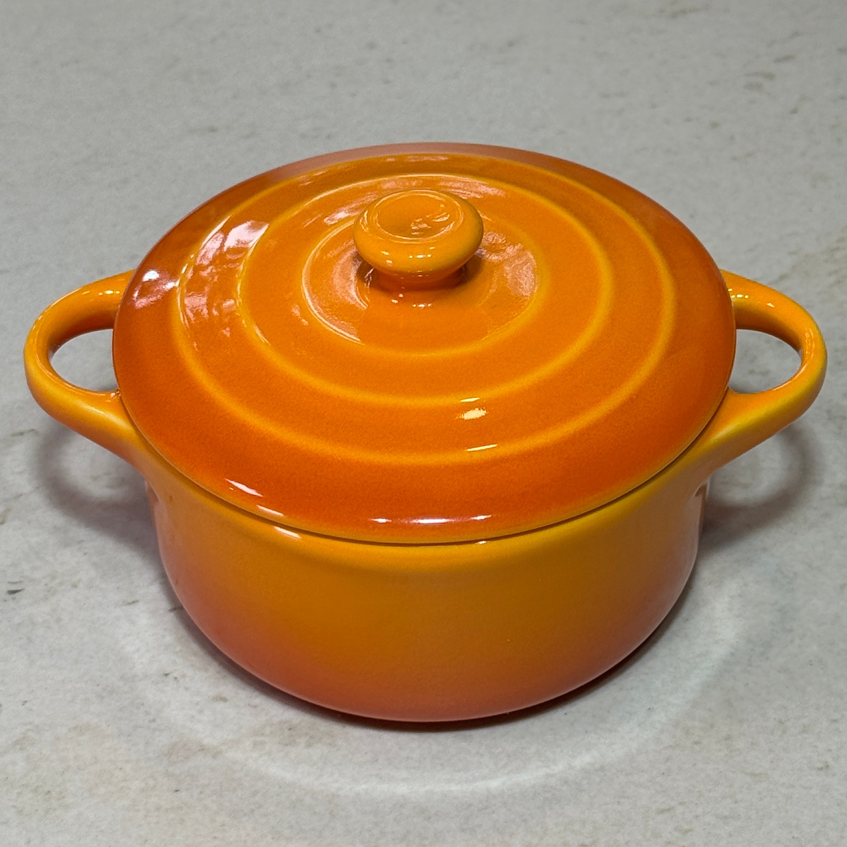 Mini cocotte en céramique émaillée jaune au design traditionnel avec trois cercles sur le couvercle.