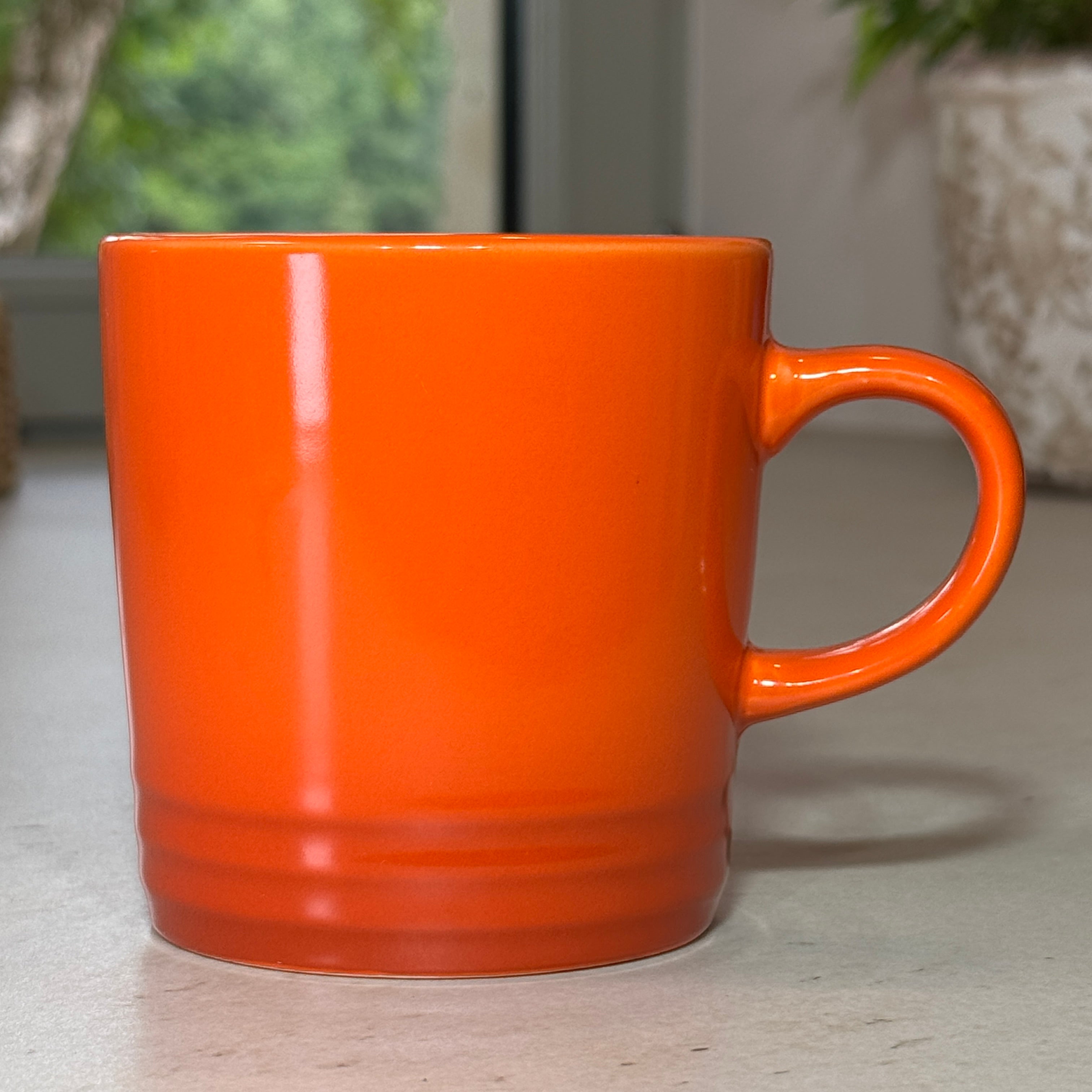 Mug en céramique émaillée orange 350 ml au design intemporel avec trois cercles en relief à la base.