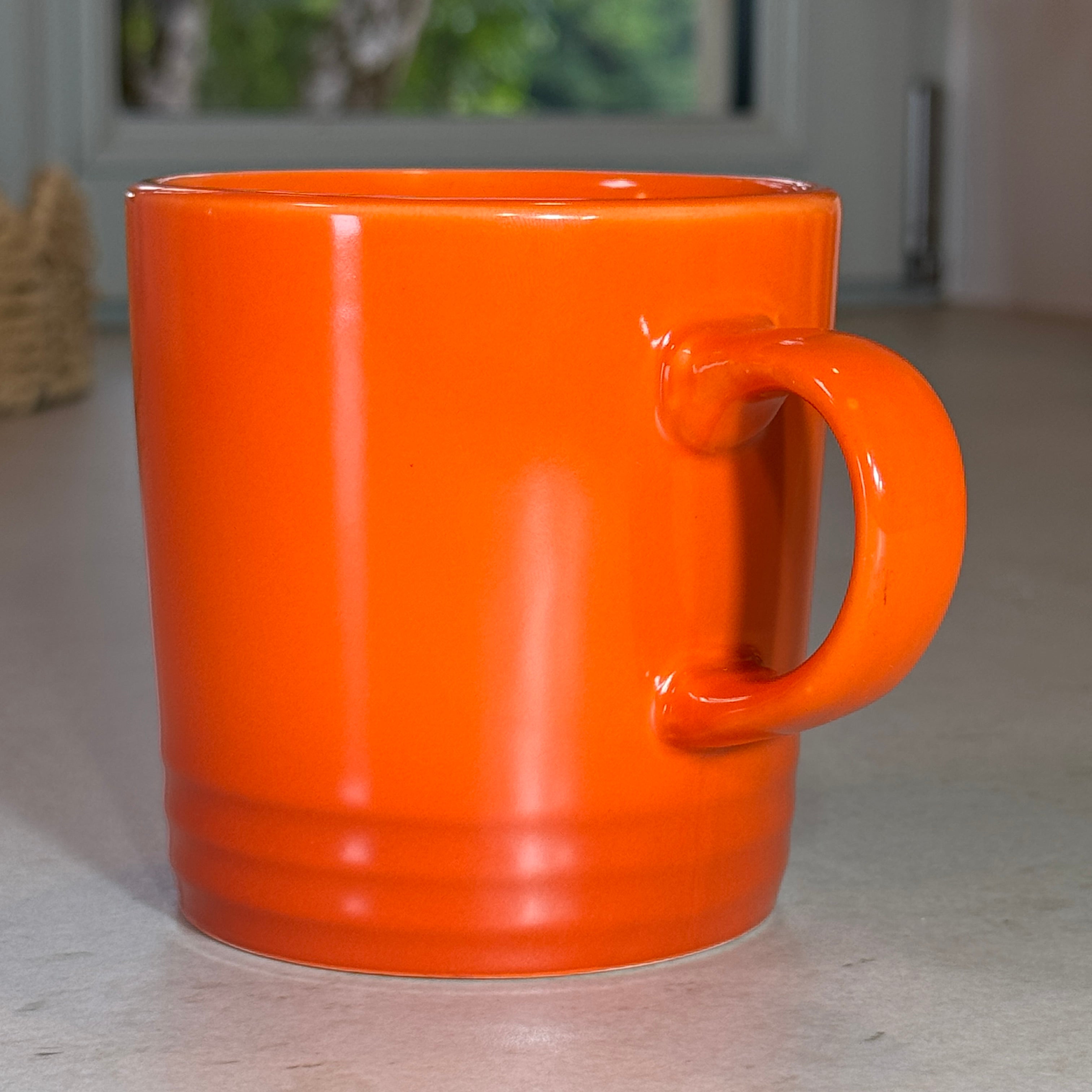 Vue de profil du mug en céramique émaillée orange 350 ml avec finition brillante et anse confortable.