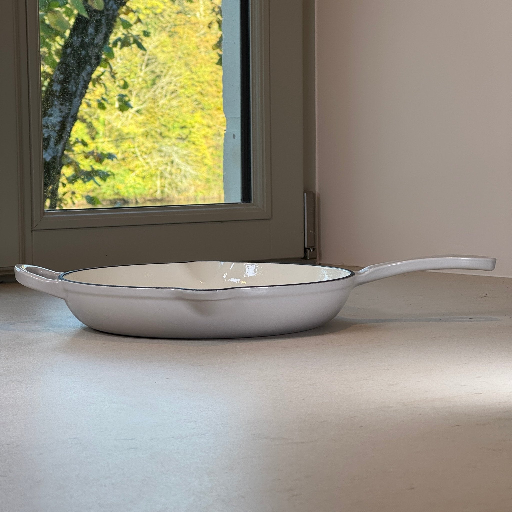 Poêle ronde en fonte émaillée Gris Meringue avec une anse et une longue poignée pour une manipulation confortable