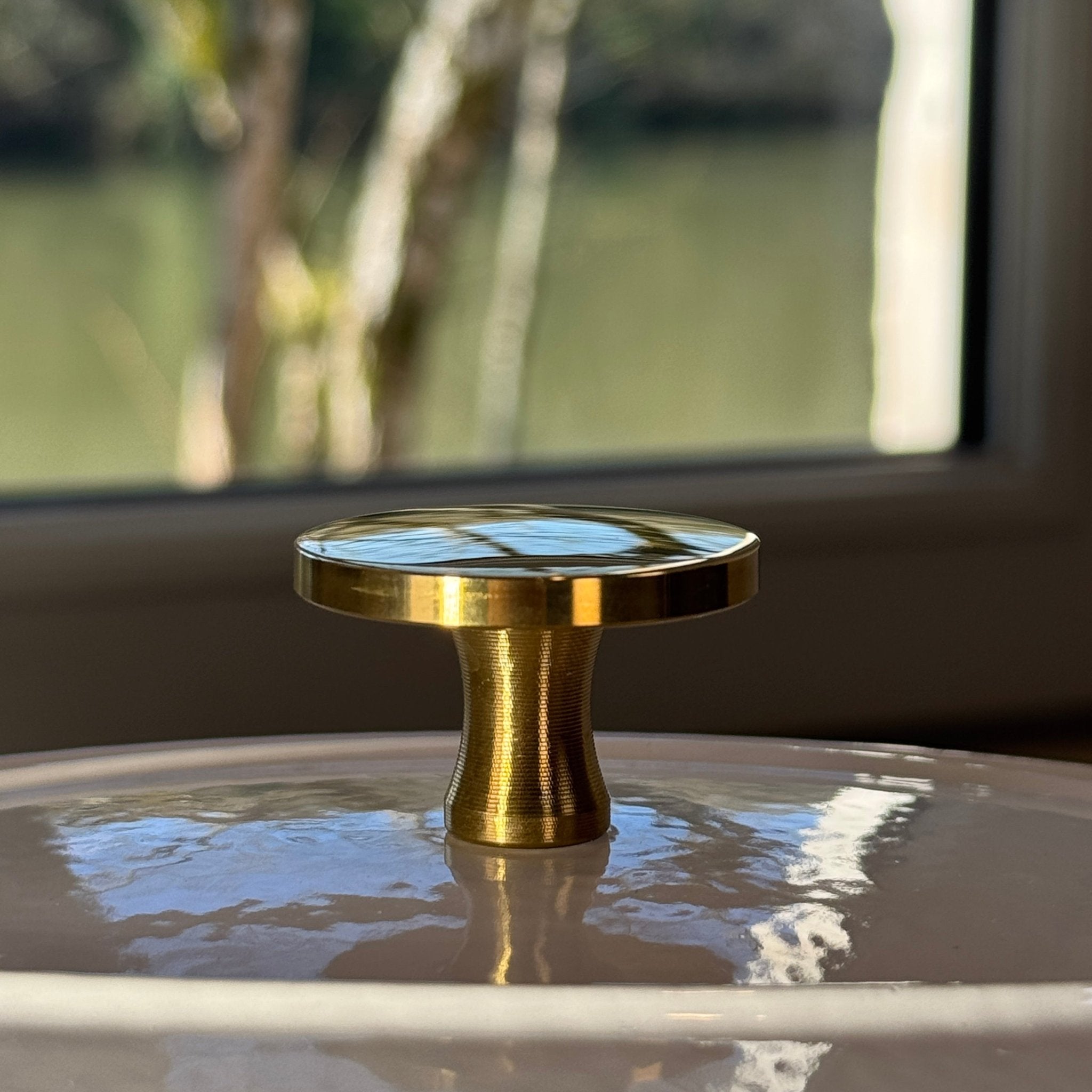 Shiny gold button adaptable to all lids