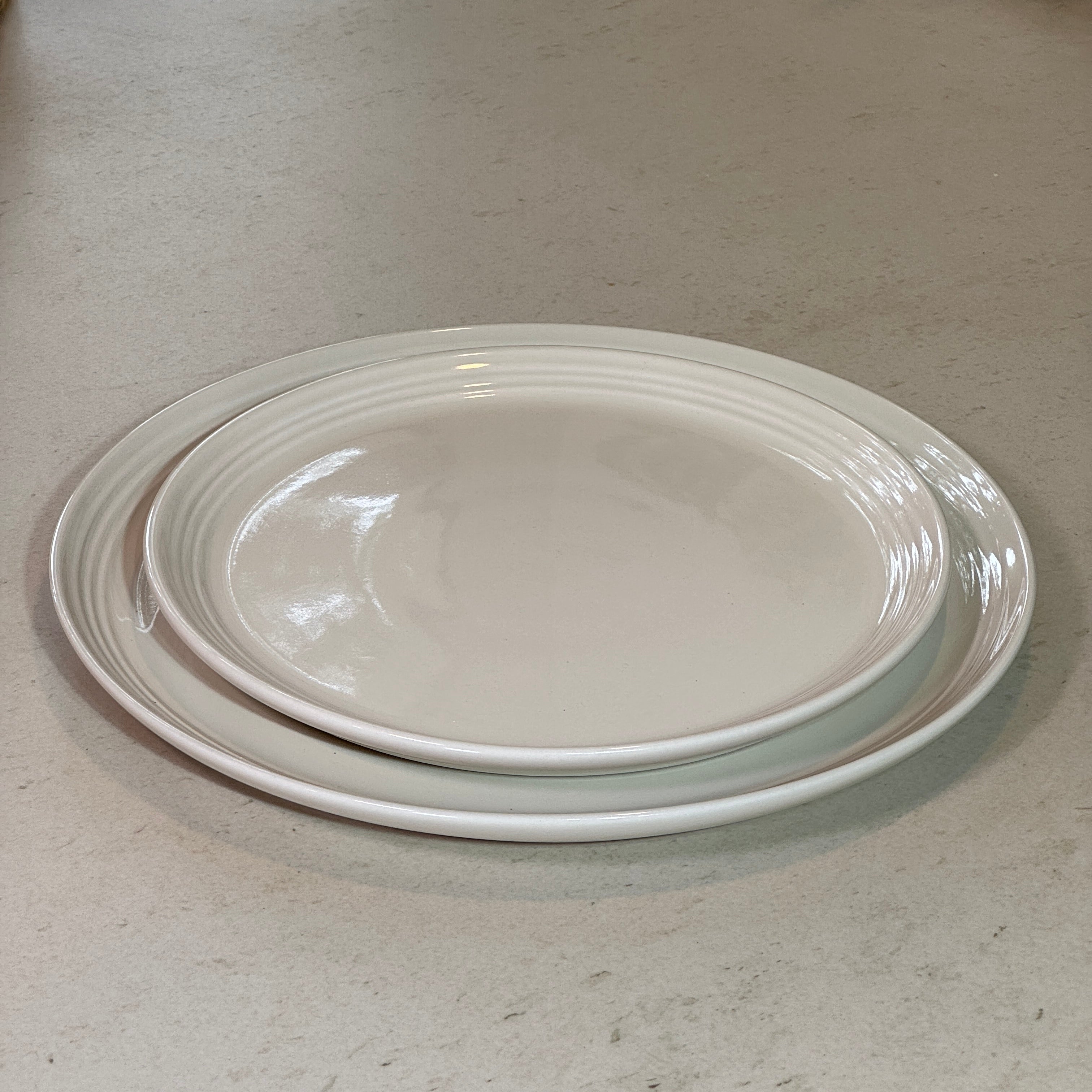 Assiette à dessert 22 cm et assiette plate 27 cm en céramique émaillée blanc, idéales pour dresser une table élégante.
