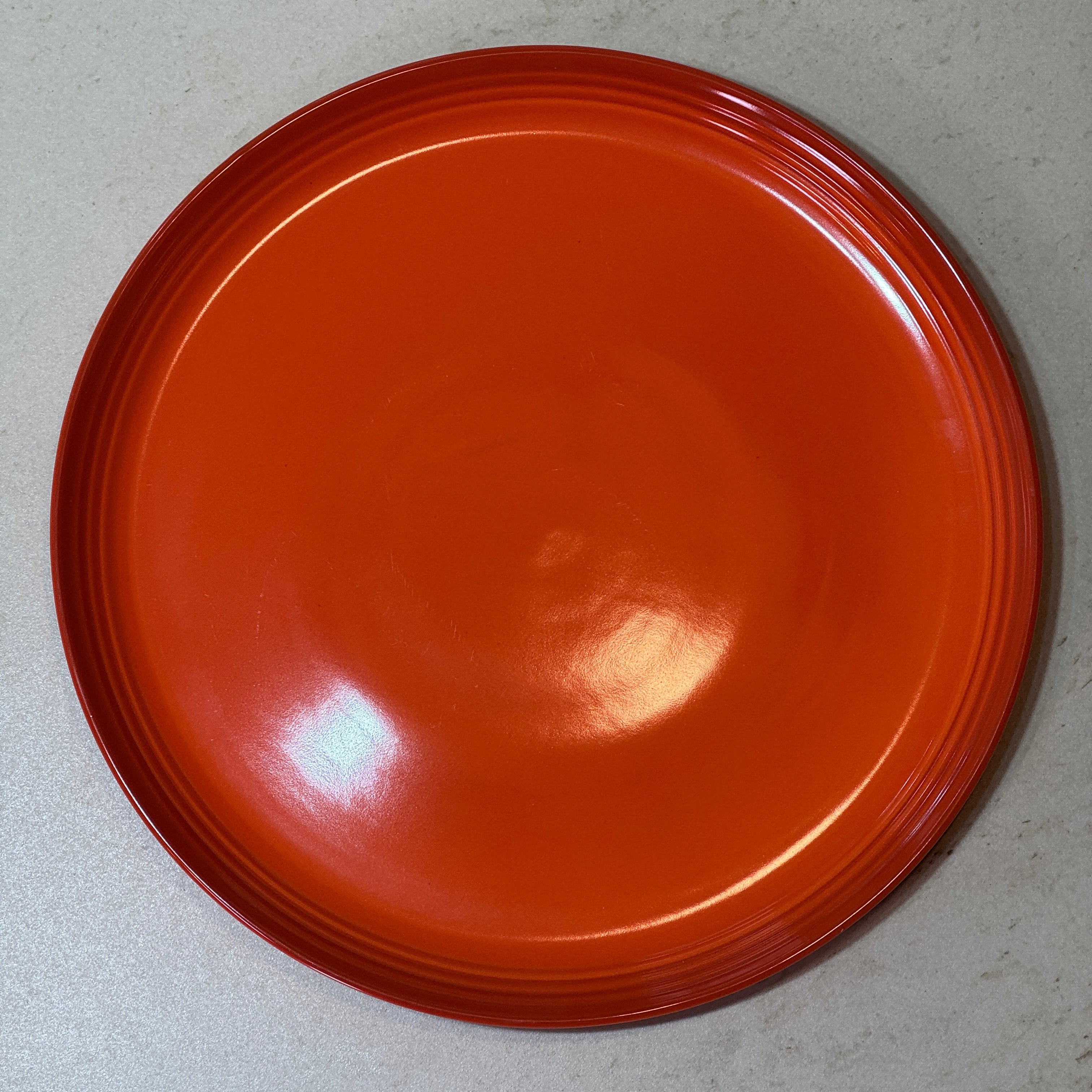 Assiette plate 27 cm en céramique émaillée orange, parfaite pour les plats principaux, grillades, pâtes et salades.