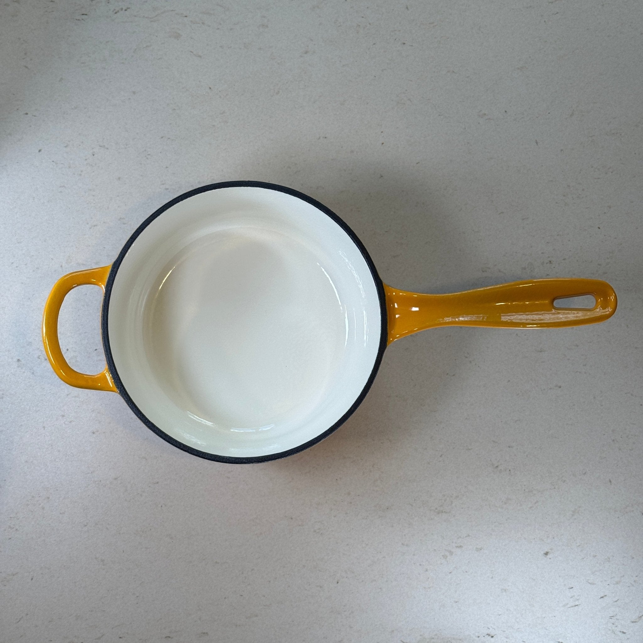 Intérieur anti adhésif clair d’une casserole en fonte émaillée Jaune Moutarde idéale pour sauces, crèmes et préparations délicates