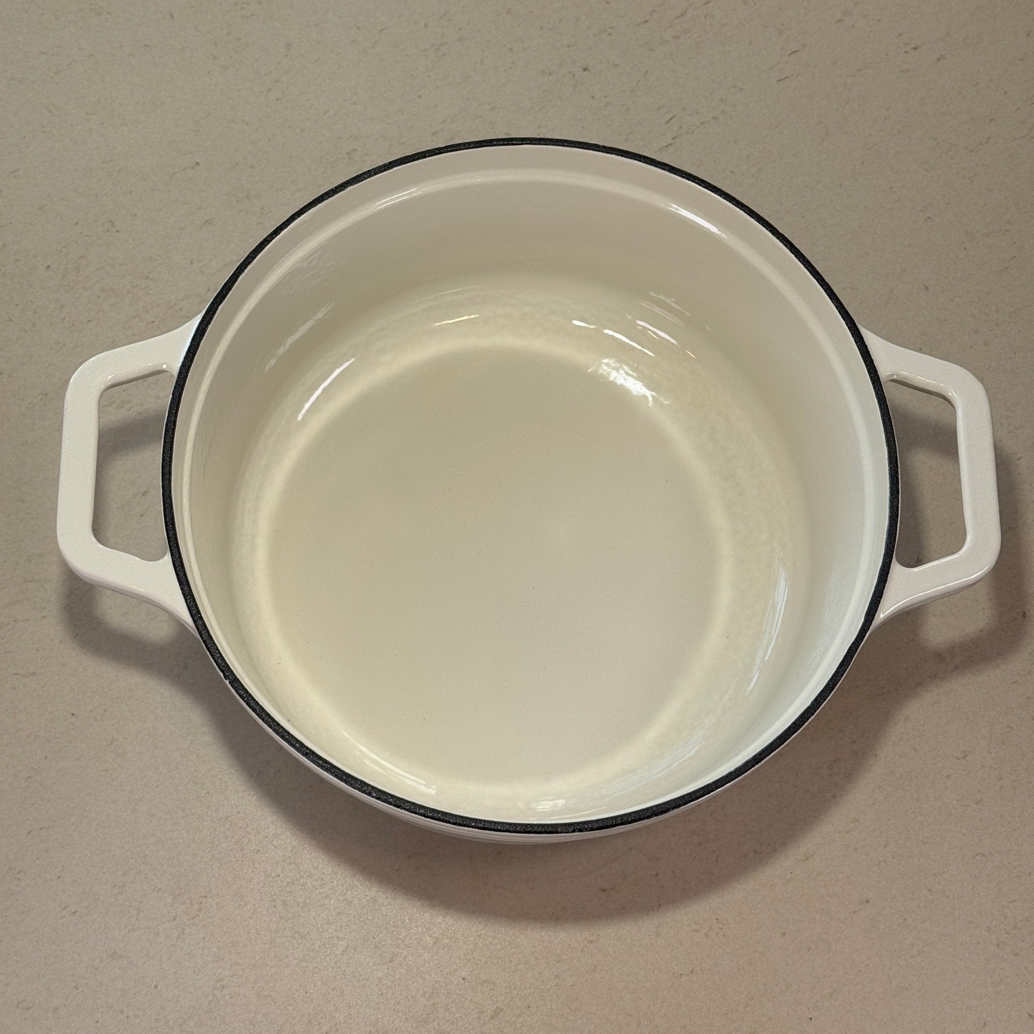 Intérieur anti adhésif clair d’une cocotte classique en fonte émaillée Blanc Vanille pour cuisson homogène et facile à nettoyer
