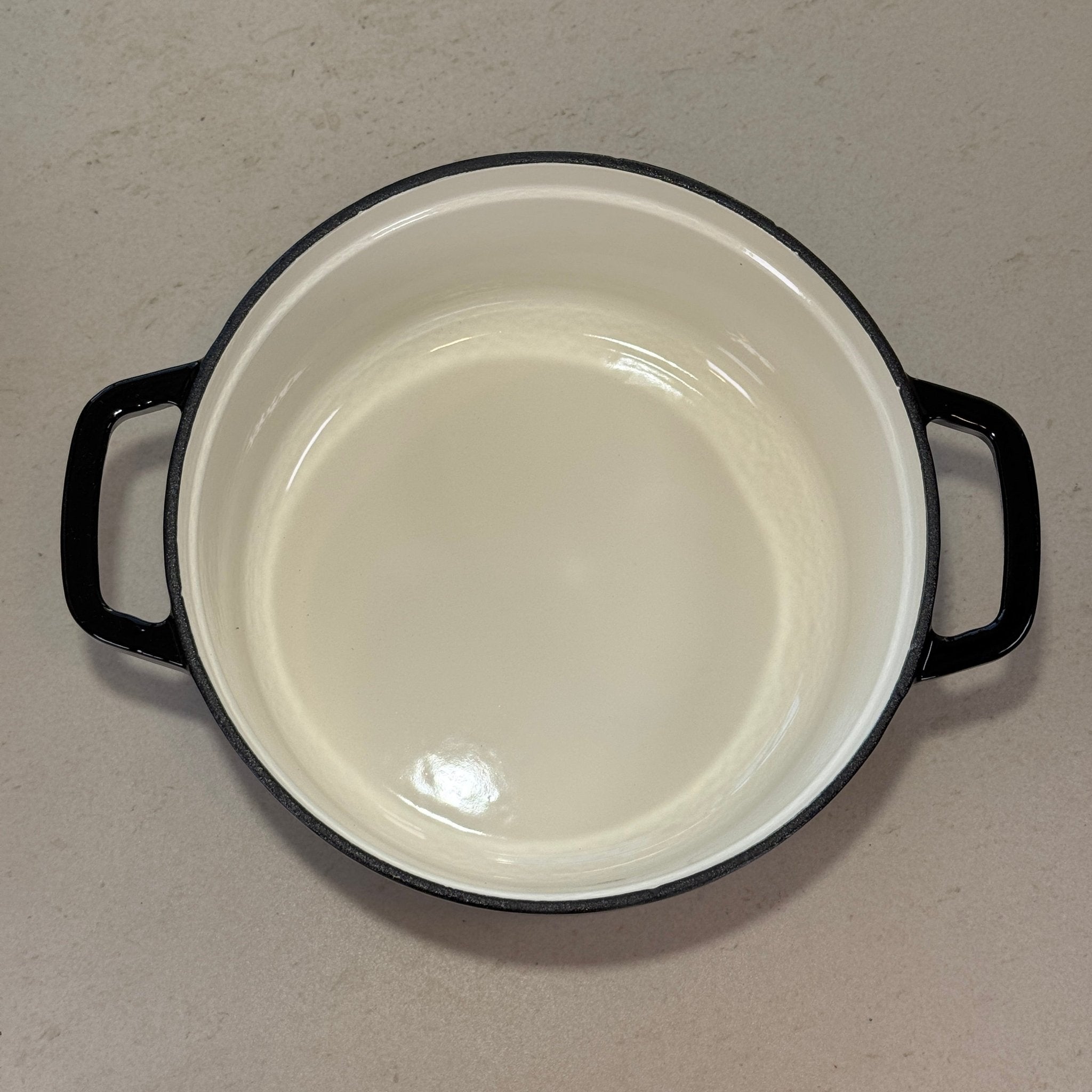 Intérieur anti adhésif clair d’une cocotte classique en fonte émaillée Noir Brillant pour cuisson homogène et facile à nettoyer