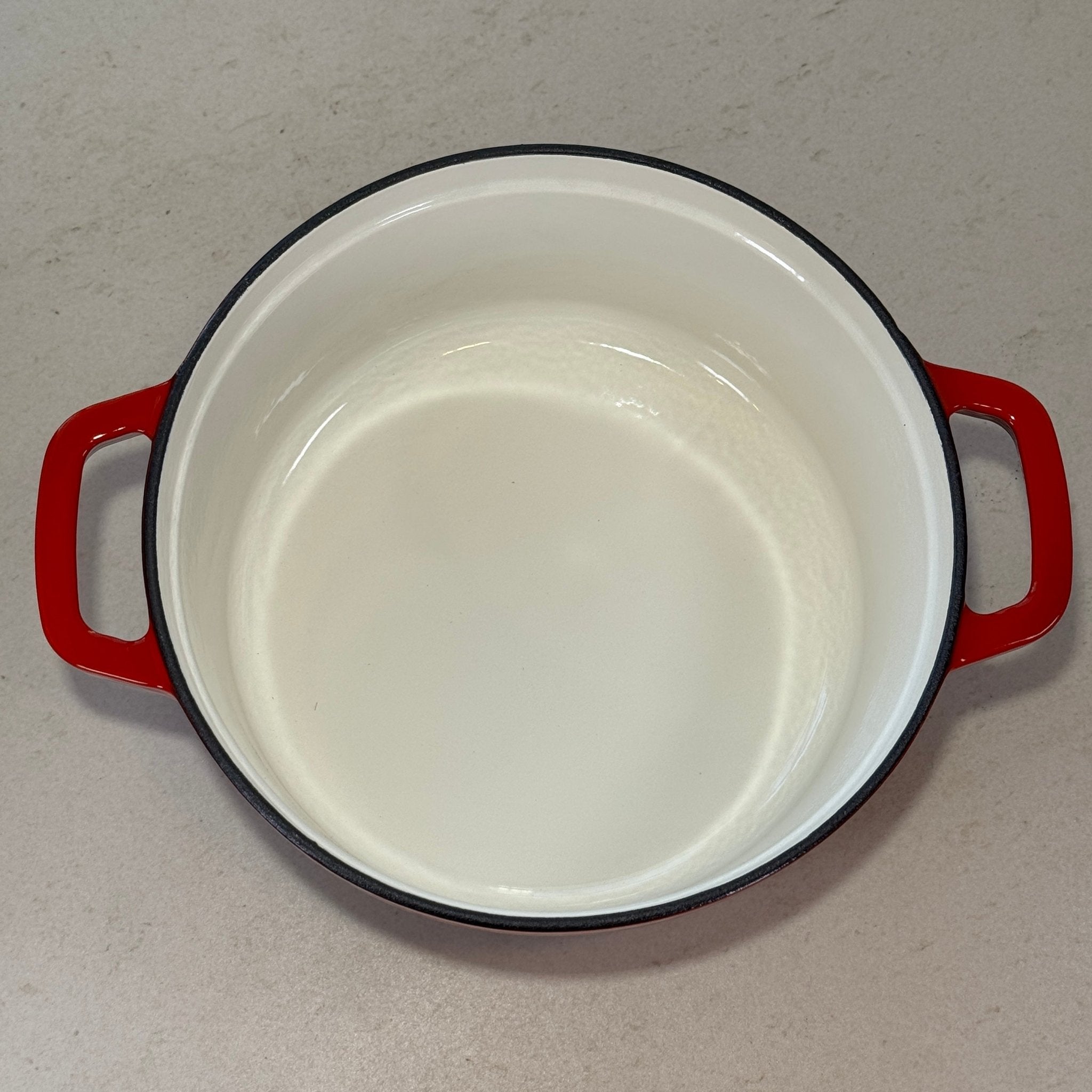 Intérieur anti adhésif clair d’une cocotte classique en fonte émaillée Rouge Cerise pour cuisson homogène et facile à nettoyer