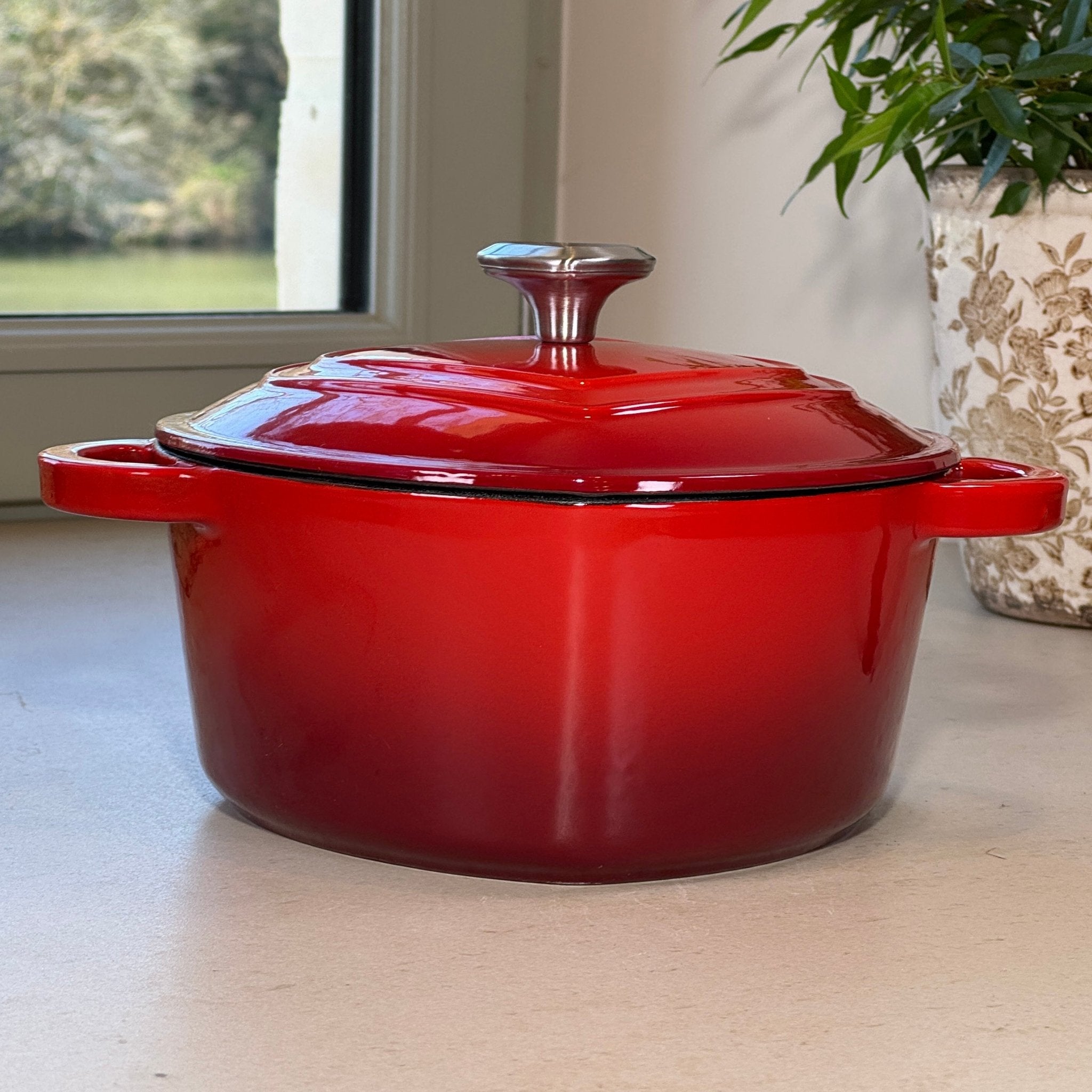 Cocotte en fonte émaillée rouge en forme de cœur posée sur plan de cuisine