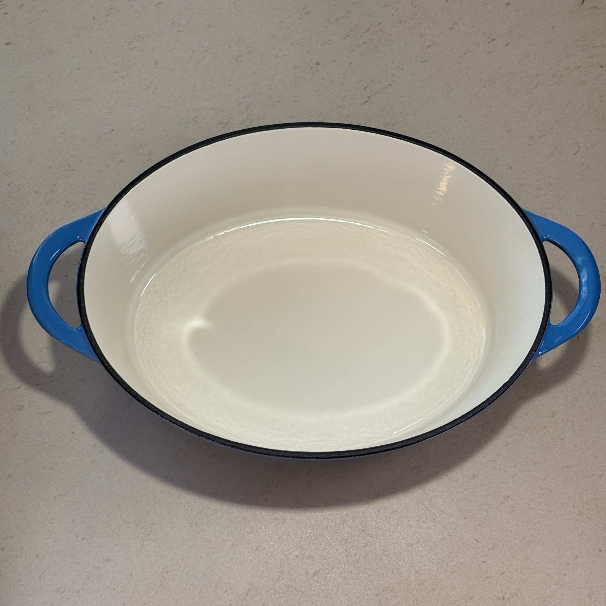 Intérieur d’une cocotte ovale en fonte émaillée bleue perle pour cuisson mijotée au four ou sur plaque