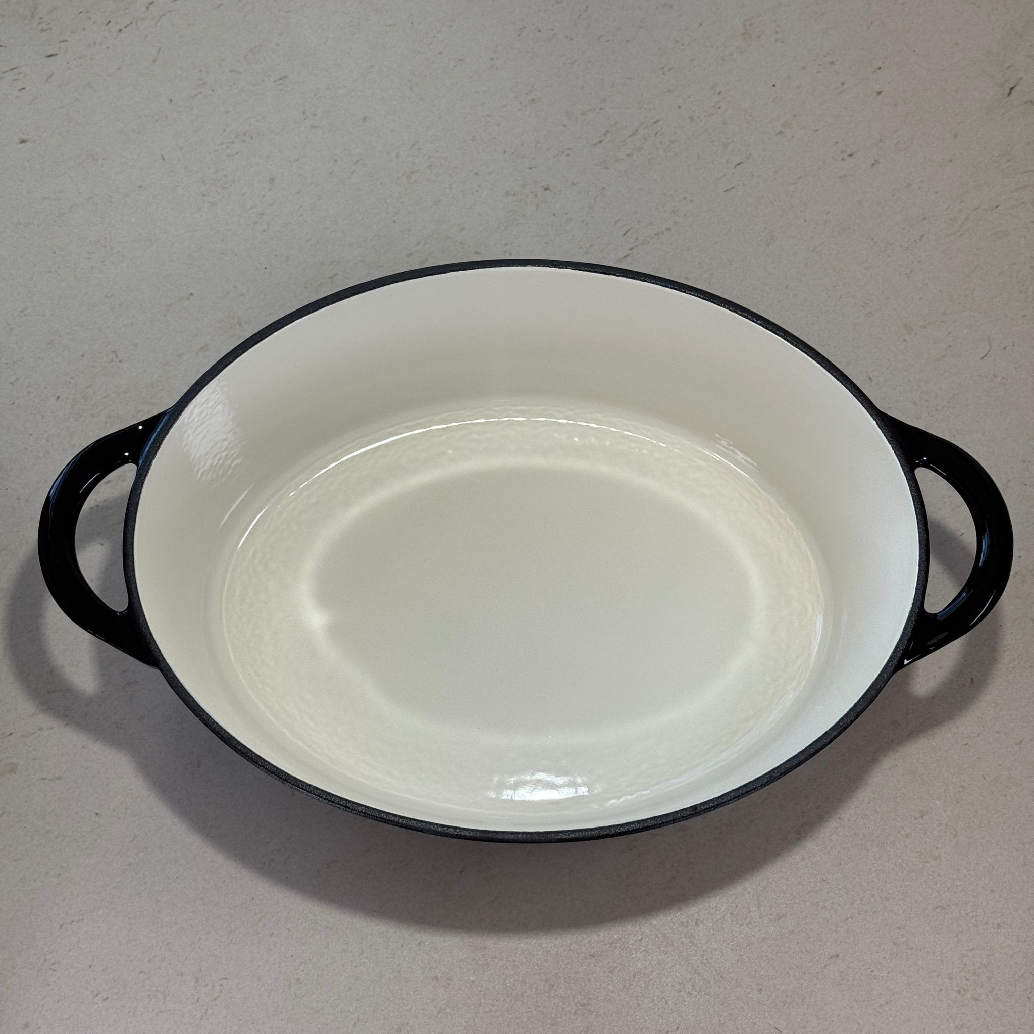 Intérieur d’une cocotte ovale en fonte émaillée noir brillant pour cuisson mijotée au four ou sur plaque