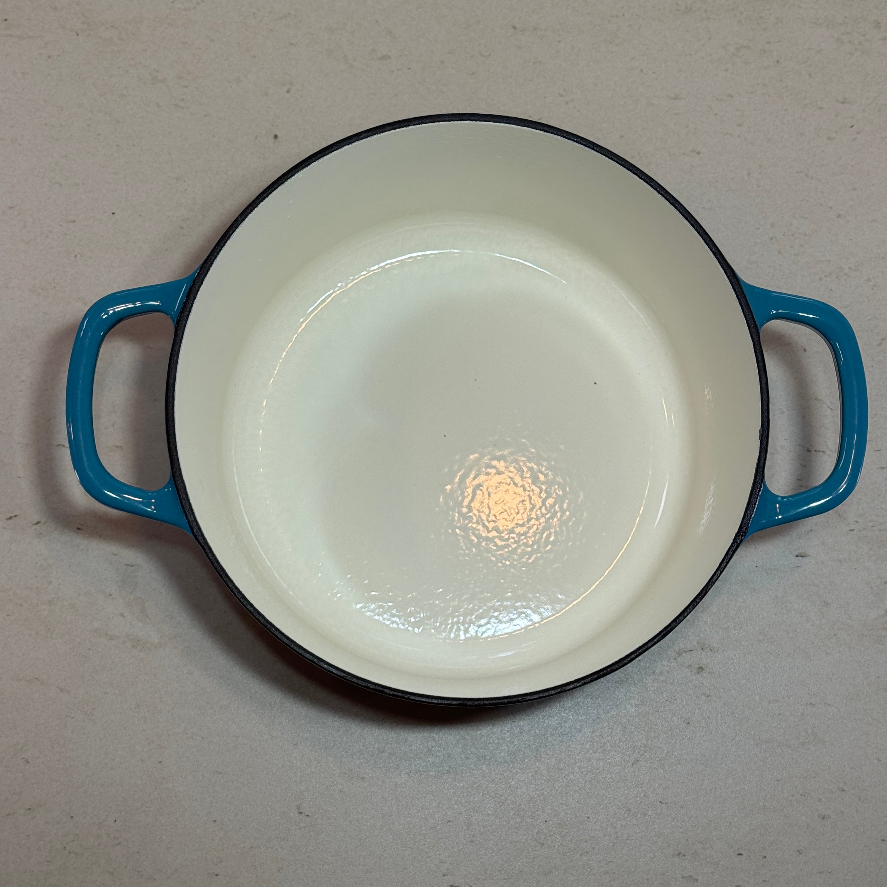 Intérieur anti adhésif clair d’une cocotte ronde en fonte émaillée Turquoise pour cuisson homogène et facile à nettoyer