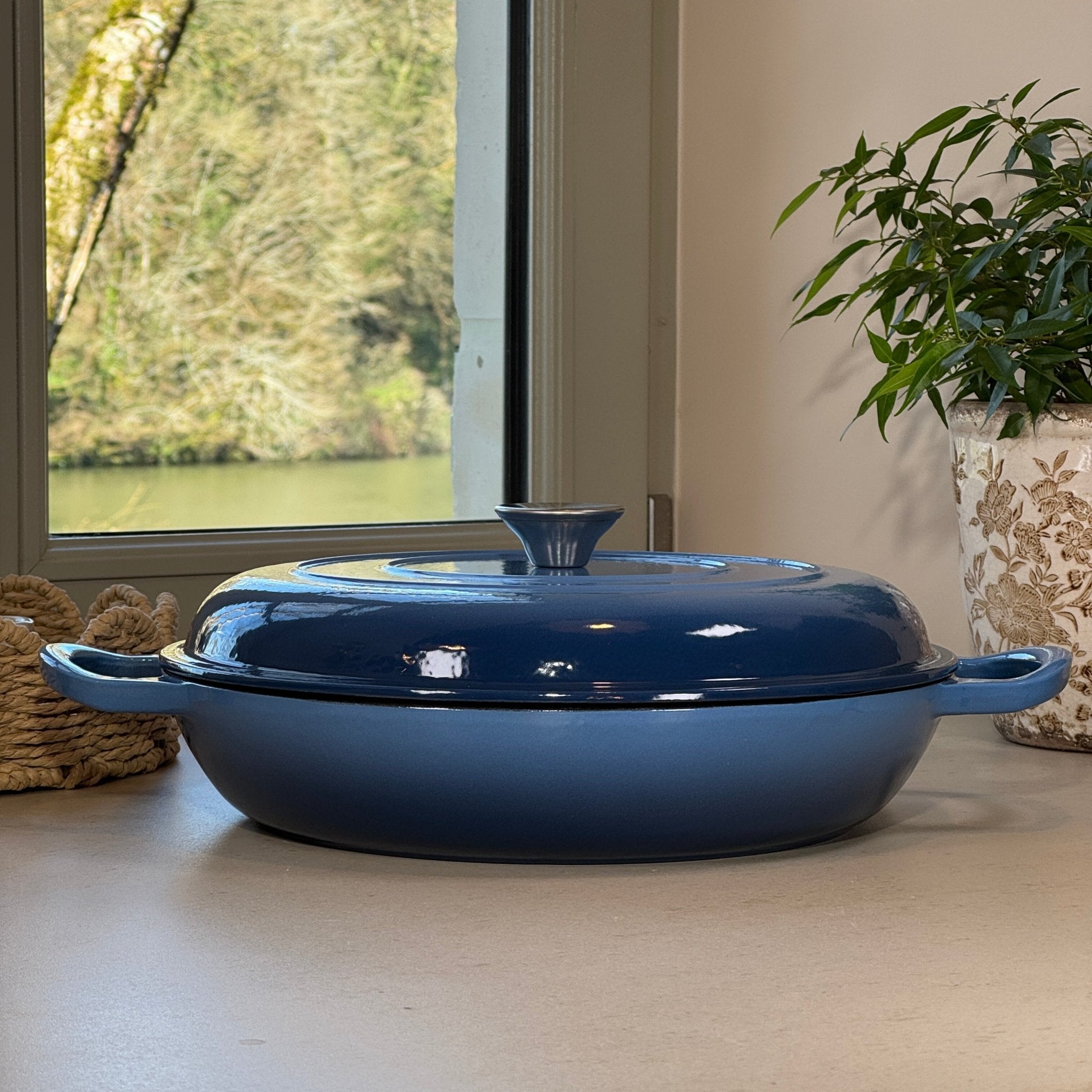 Faitout en fonte émaillée bleu perle design posé sur plan de travail de cuisine moderne