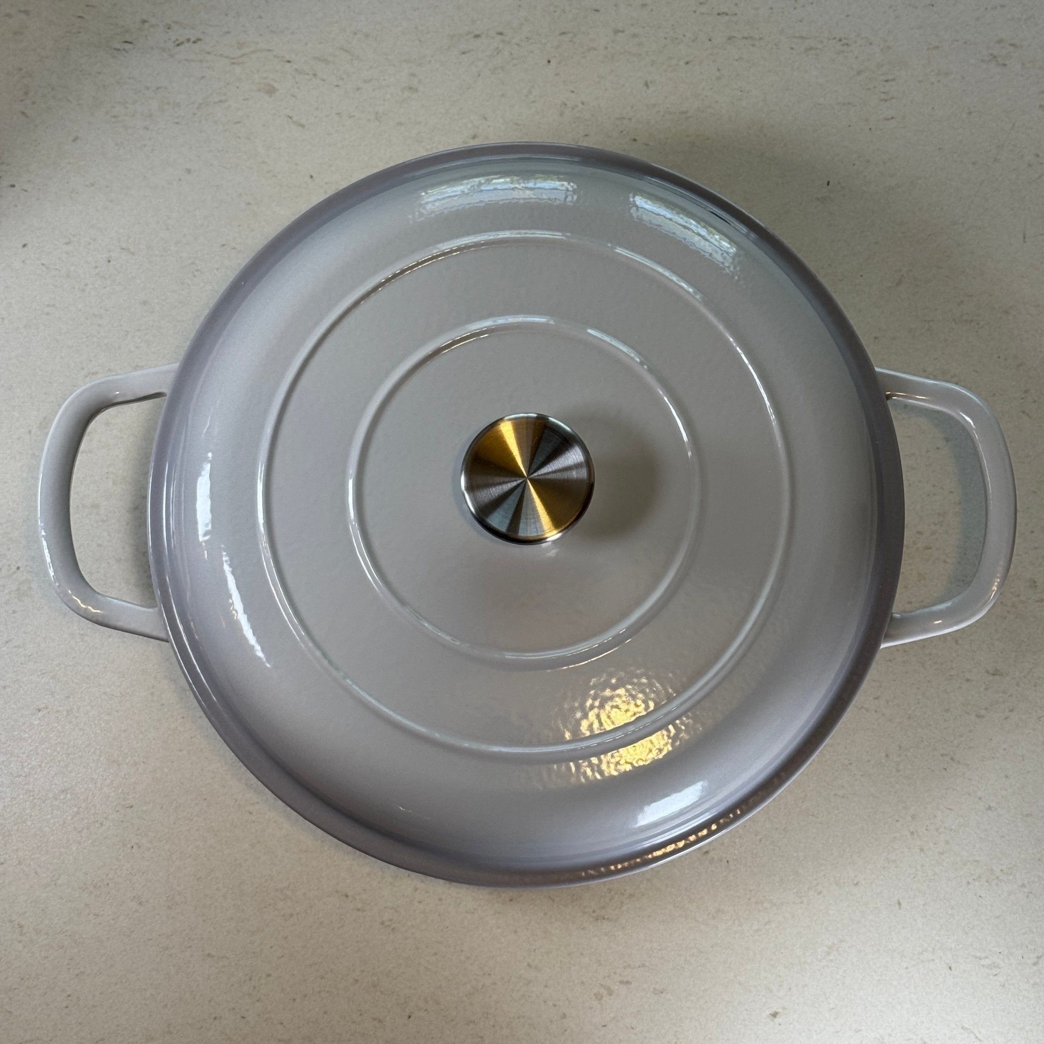 Faitout en fonte émaillée gris meringue avec couvercle à picots assurant un arrosage naturel des plats pendant la cuisson