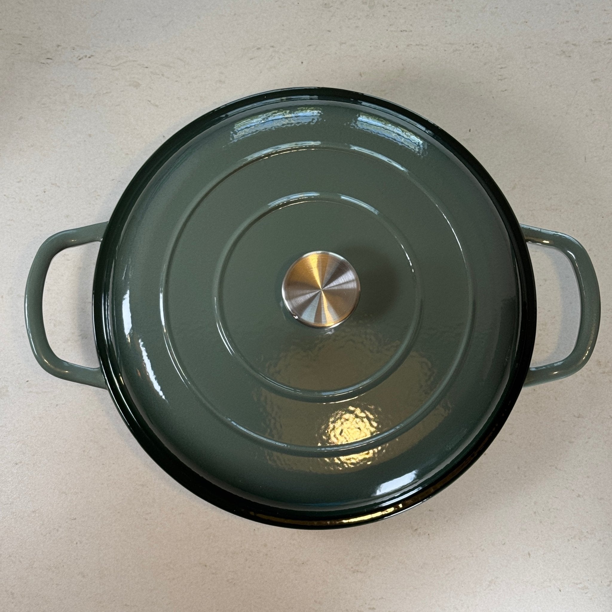 Faitout en fonte émaillée vert sapin avec couvercle à picots assurant un arrosage naturel des plats pendant la cuisson