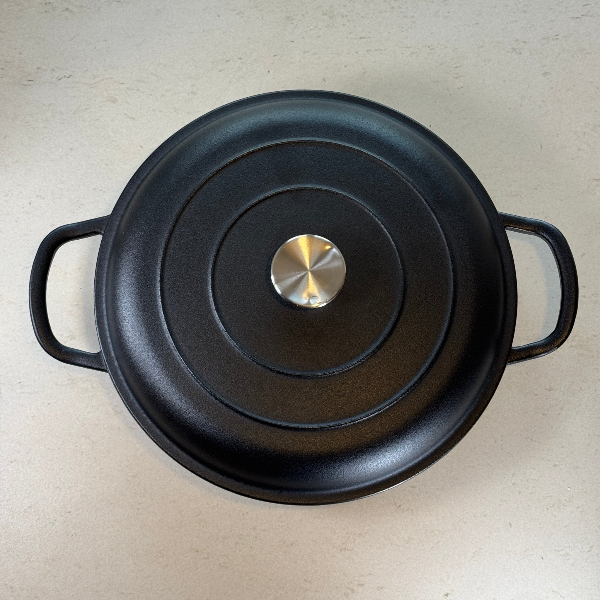 Faitout en fonte noir mat avec couvercle à picots assurant un arrosage naturel des plats pendant la cuisson