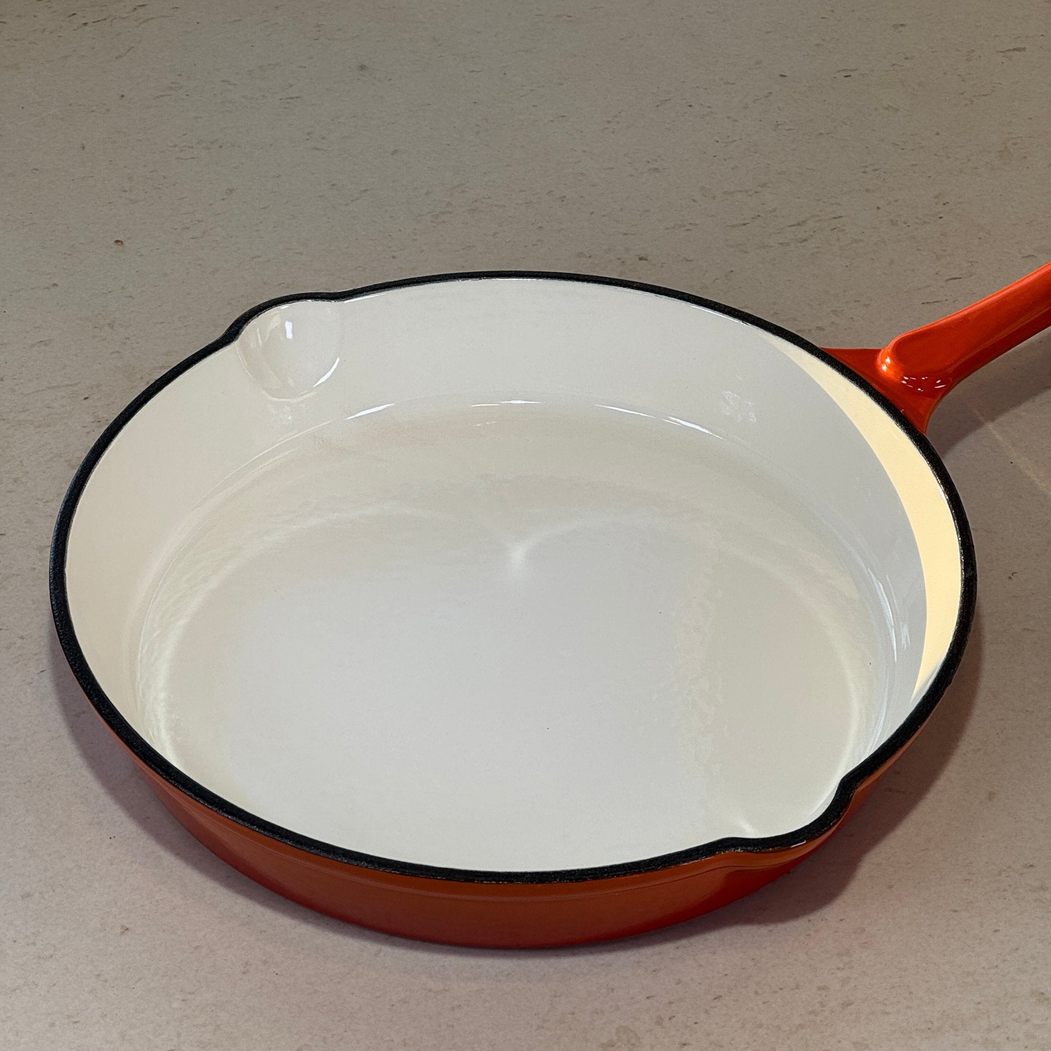 Grande poêle en fonte émaillée orange avec surface lisse pour cuisson homogène