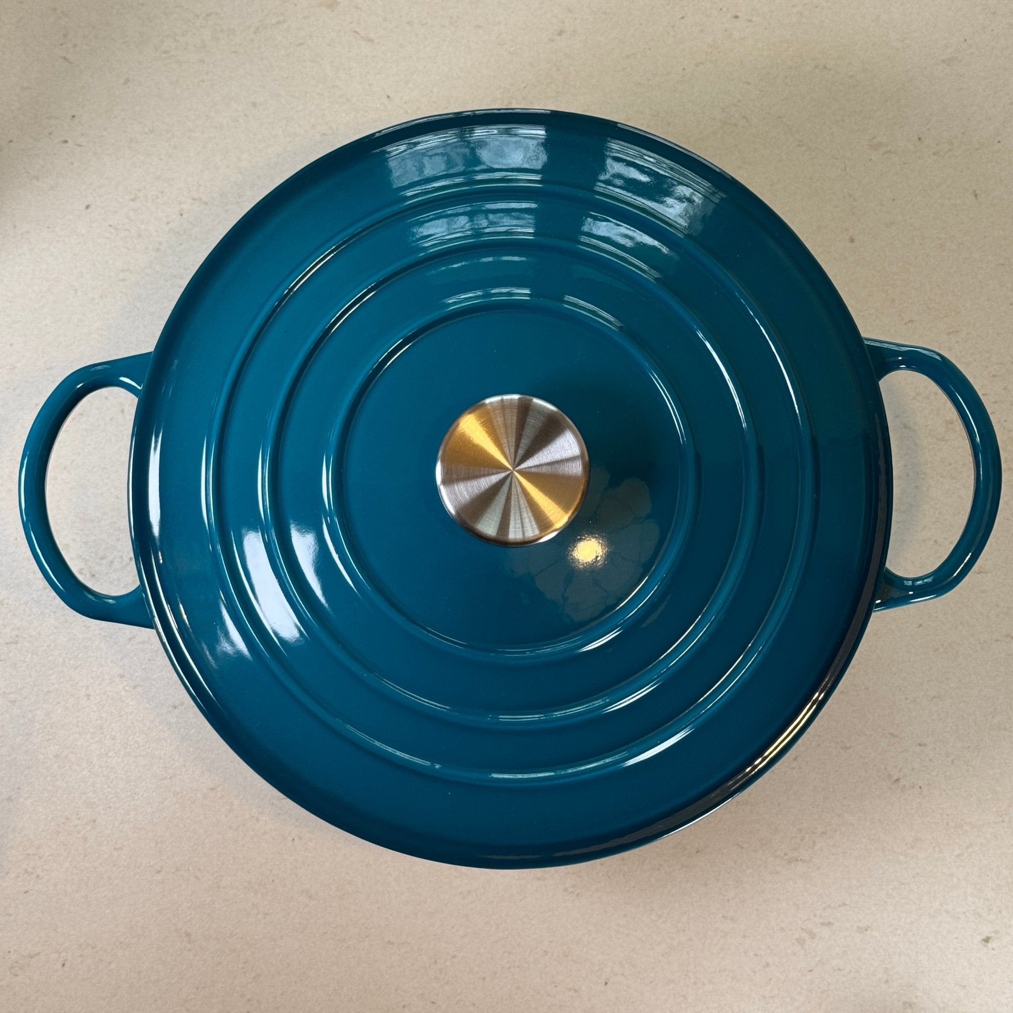 Marmite ronde en fonte émaillée bleu cyan adaptée à la cuisson de sauces, béchamel et préparations à base de lait