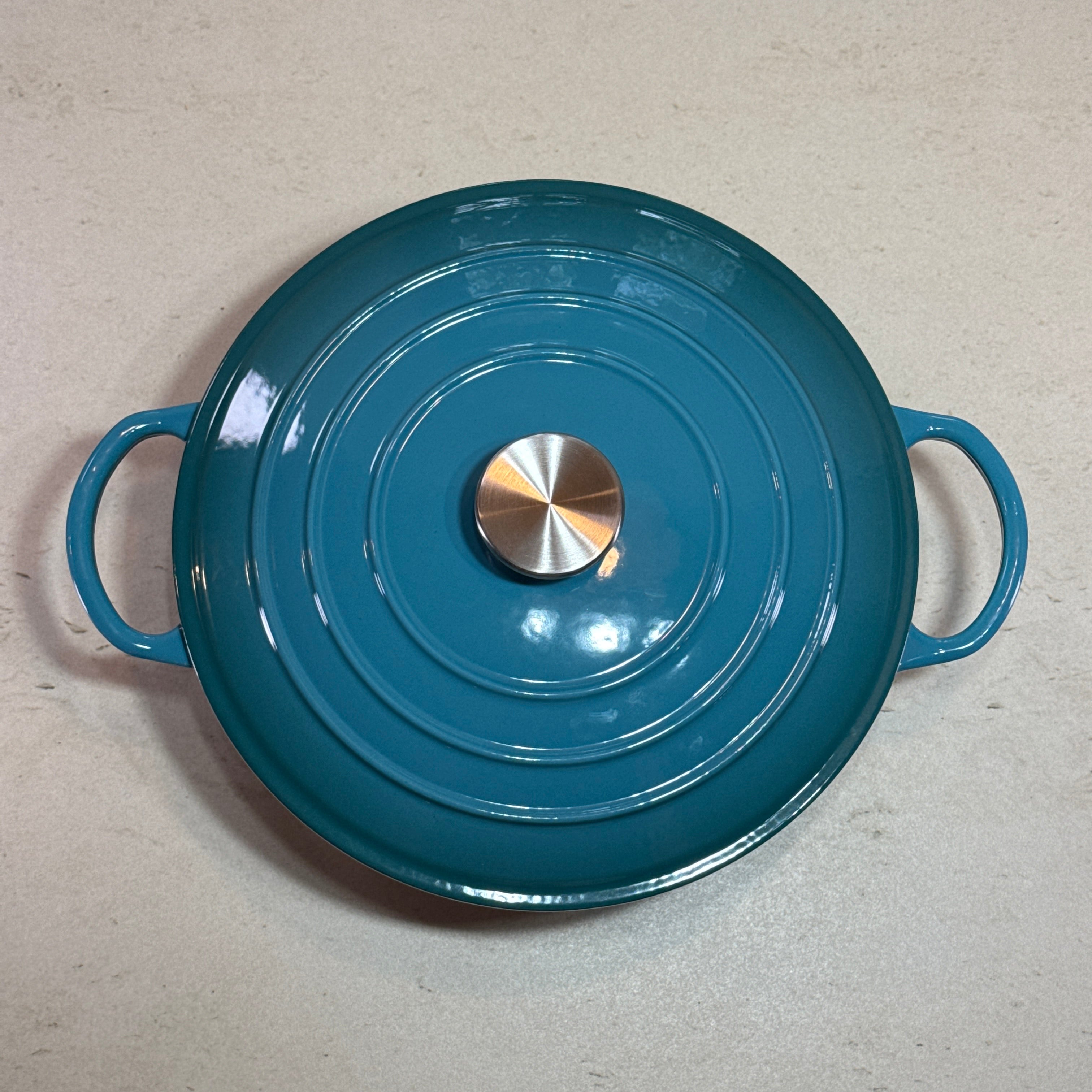 Marmite ronde en fonte émaillée turquoise adaptée à la cuisson de sauces, béchamel et préparations à base de lait