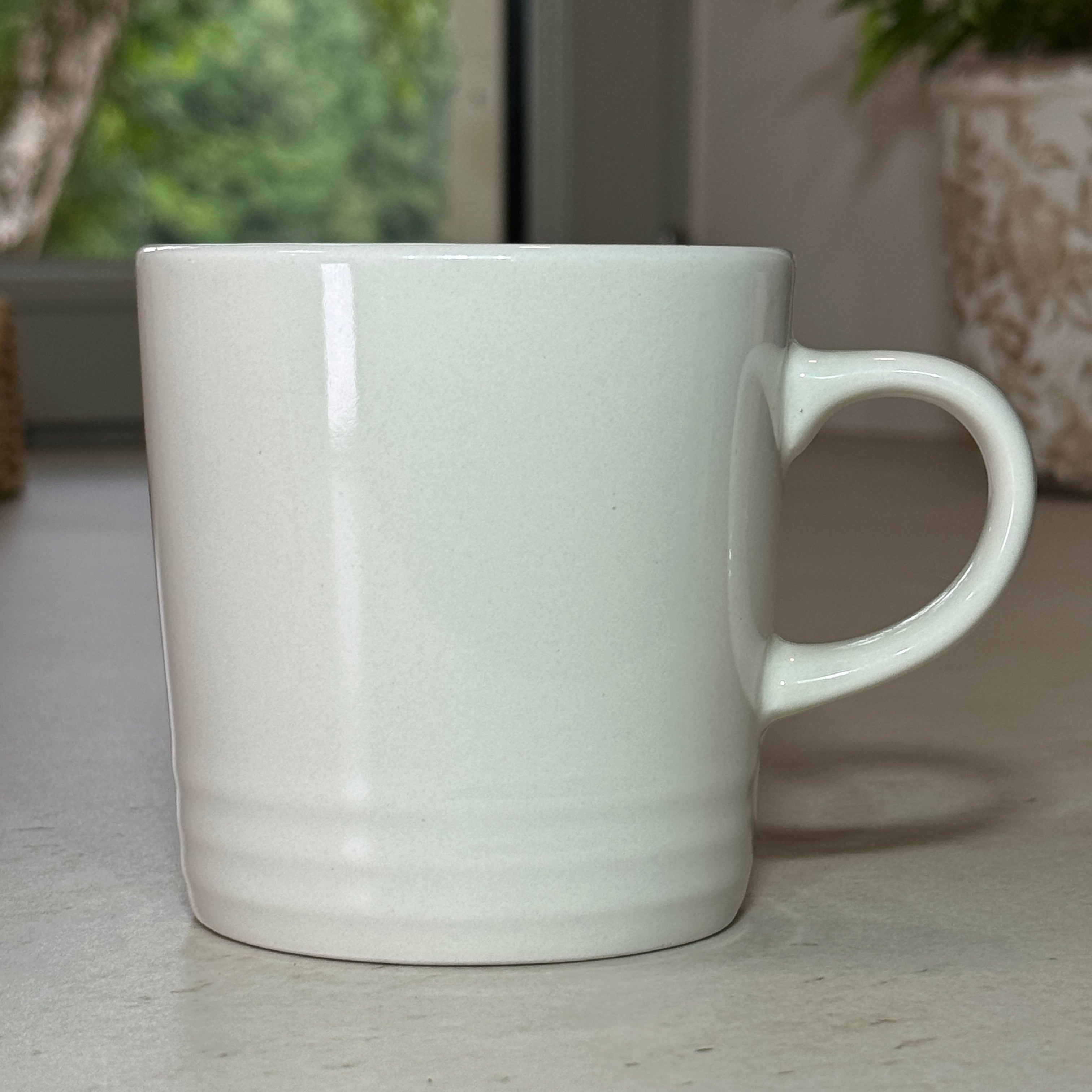 Mug en céramique émaillée blanc 350 ml au design intemporel avec trois cercles en relief à la base.