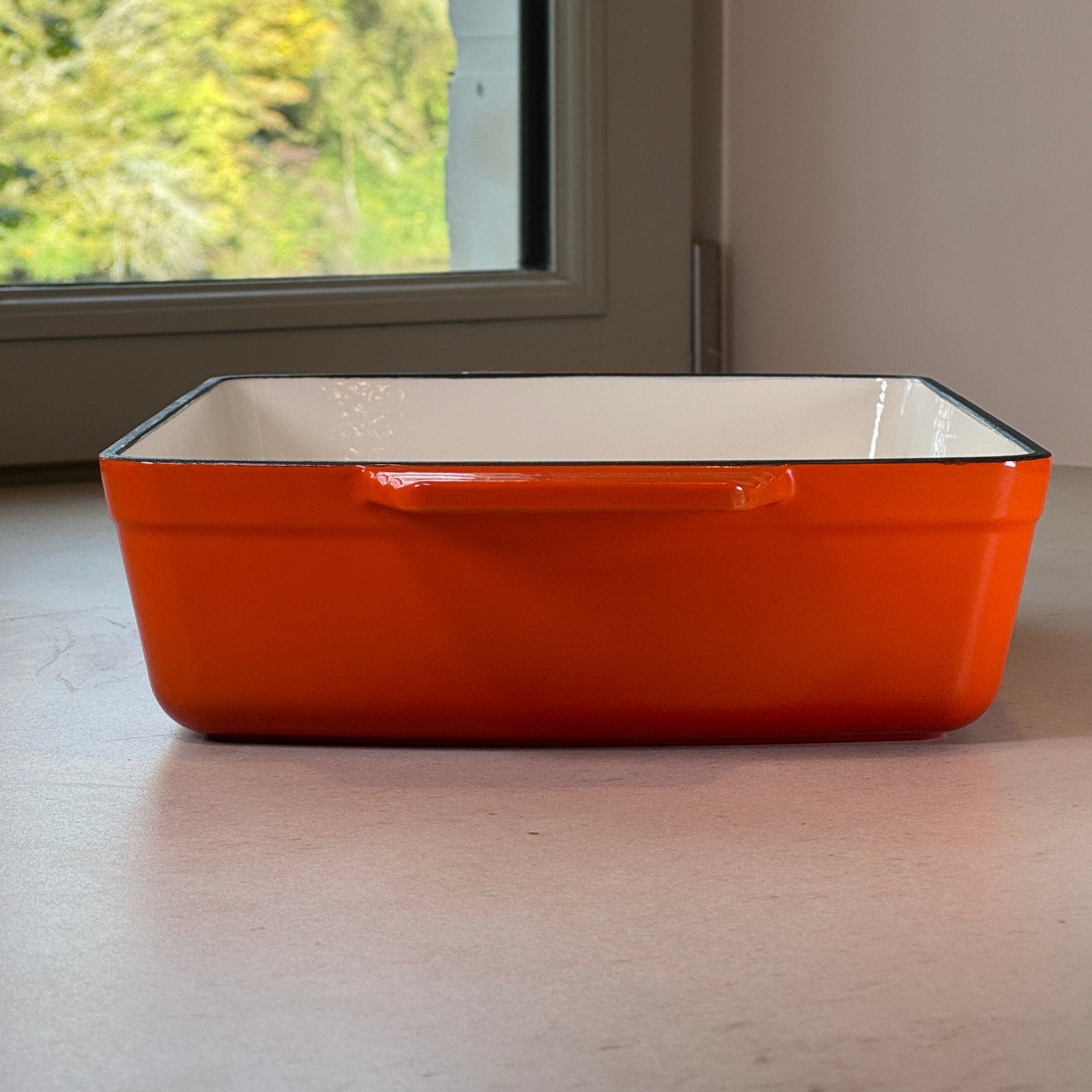 Plat à rôtir en fonte orange assurant une cuisson homogène au four pour rôtis, volailles et légumes rôtis