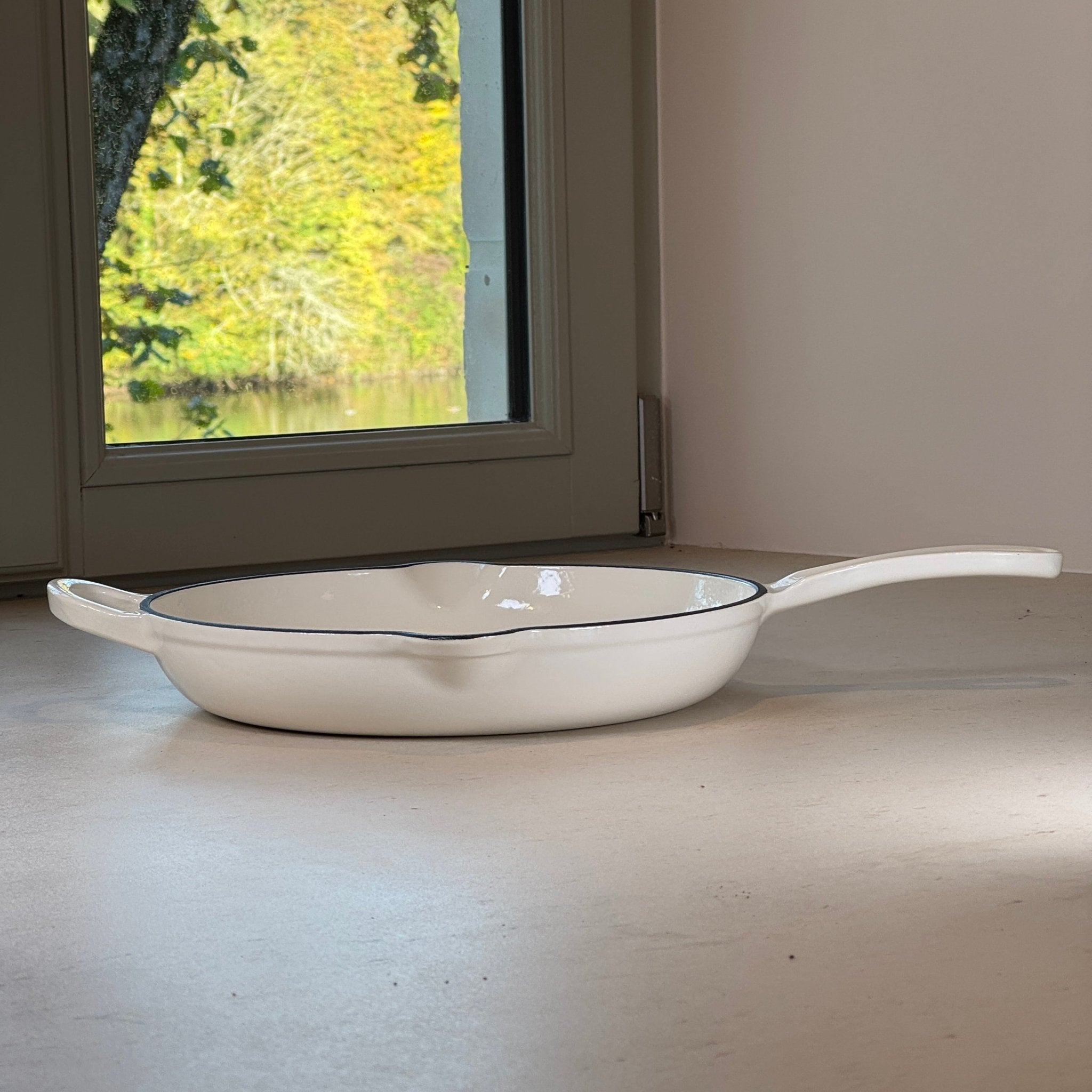 Poêle ronde en fonte émaillée Blanc Vanille avec une anse et une longue poignée pour une manipulation confortable