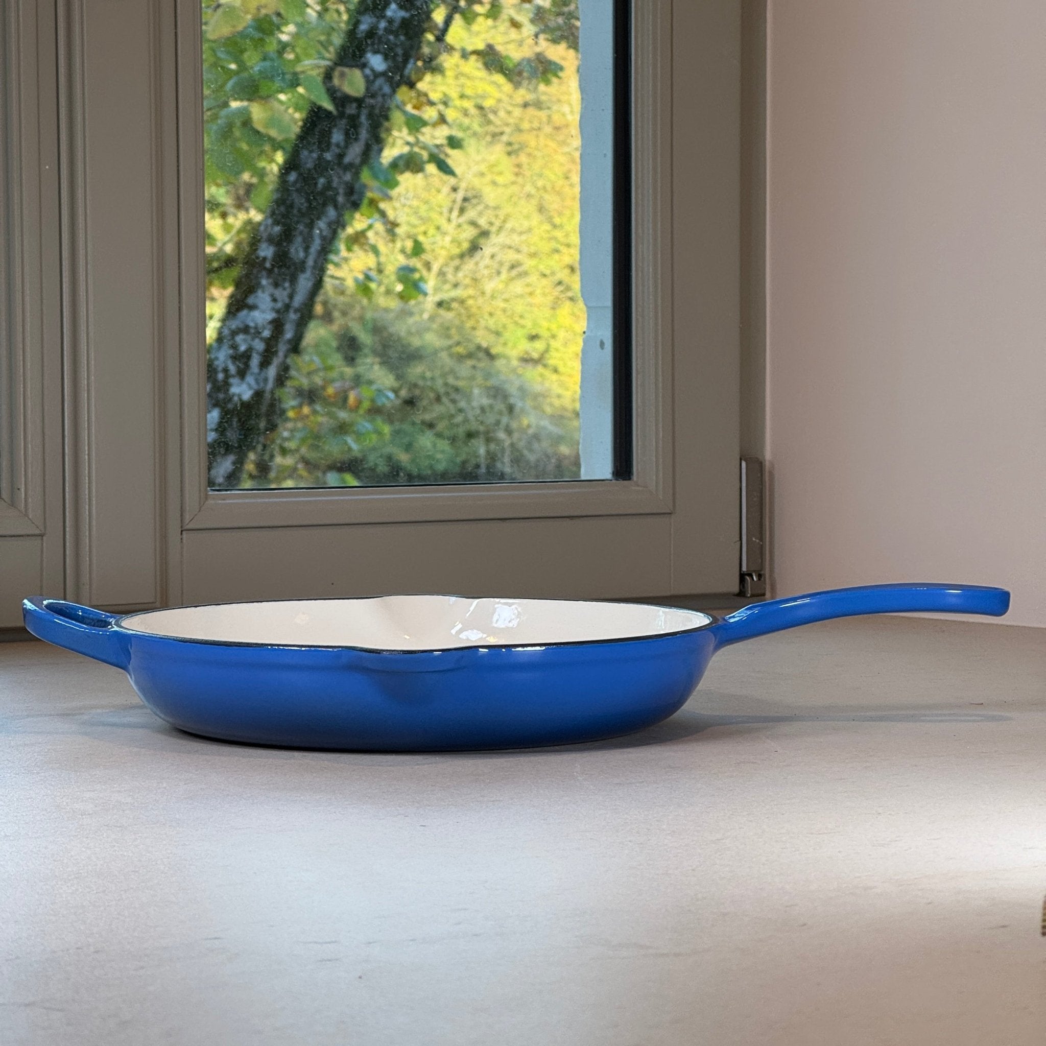 Poêle ronde en fonte émaillée Bleu Myrtille avec une anse et une longue poignée pour une manipulation confortable