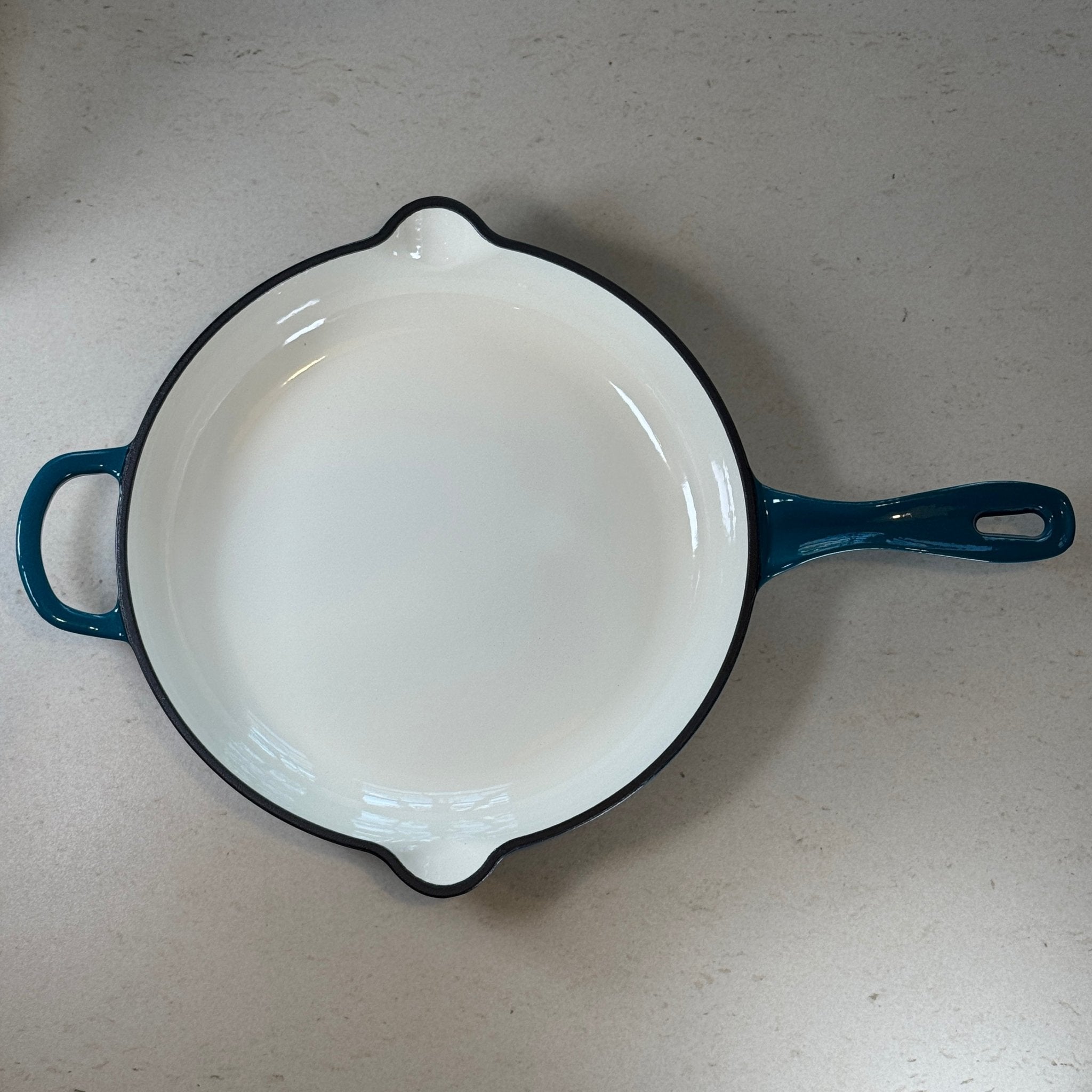 Intérieur anti adhésif clair d’une poêle en fonte émaillée Bleu Cyan pour cuisson homogène et saisie parfaite