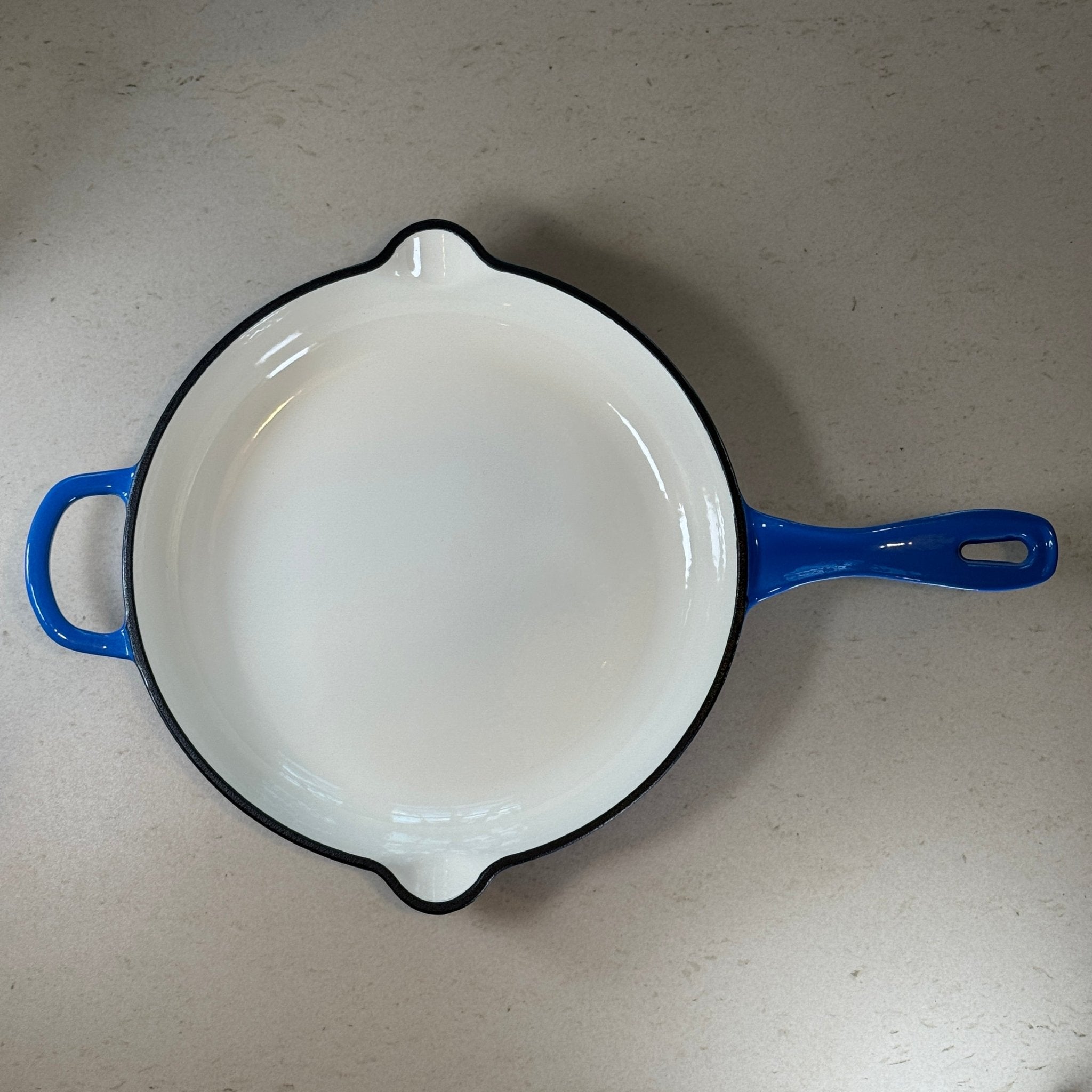 Intérieur anti adhésif clair d’une poêle en fonte émaillée Bleu Myrtille pour cuisson homogène et saisie parfaite